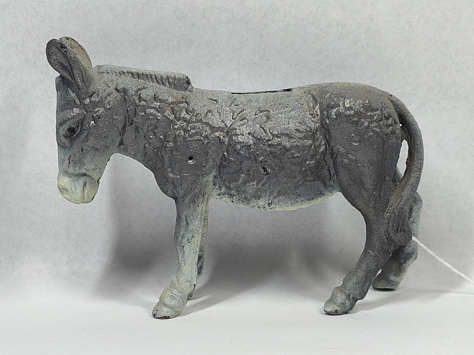 A.C. Williams Style Donkey Still Bank: 7.5 inches. Cast iron still bank depicting a standing donkey or burro, produced in the style of early 20th-century American manufacturers such as A.C. Williams or Hubley. The item is constructed from