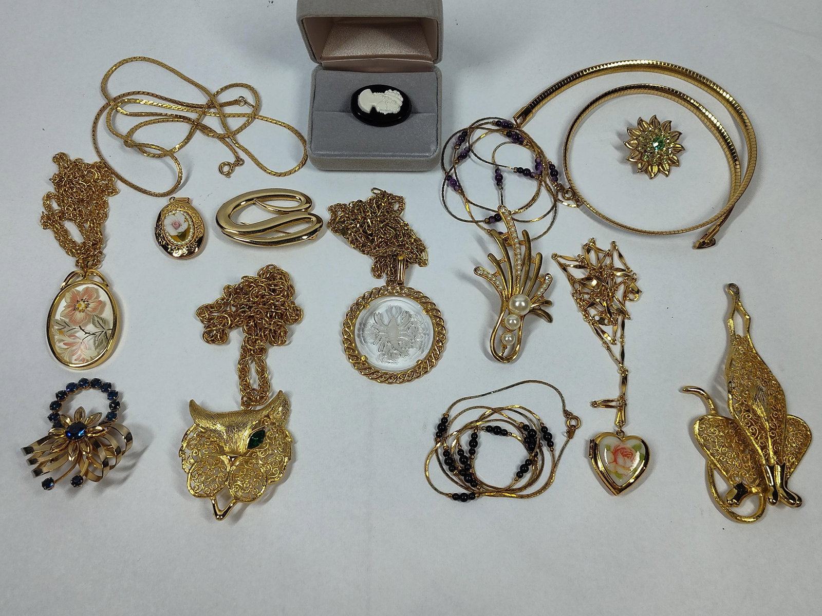 Vtg Gold-Tone Jewelry: Necklaces & More: An assortment of vintage costume jewelry, primarily constructed from gold-toned base metal. The collection includes various necklace styles: a stylized filigree leaf pendant on a flat omega collar