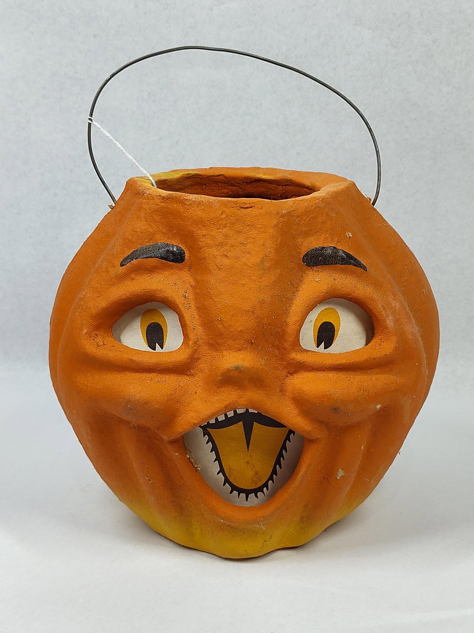 Seasons Gone By Jack-O-Lantern, 1996: 7x9x6 A contemporary molded pulp Halloween lantern bucket produced by Seasons Gone By, designed to emulate the style of vintage American pulp holiday decorations. The pumpkin form features a