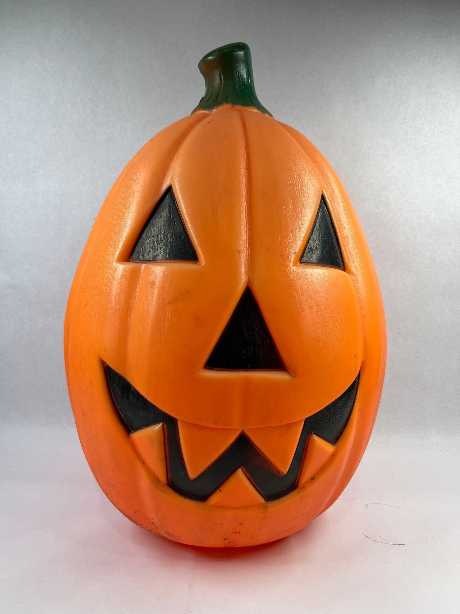 Vtg Halloween Jack-O-Lantern Blow Mold: 21 inches. A large vintage blow-molded plastic jack-o-lantern holiday decoration. The item features an elongated ovoid shape with molded vertical ribbing and is topped with an integrated stem painted