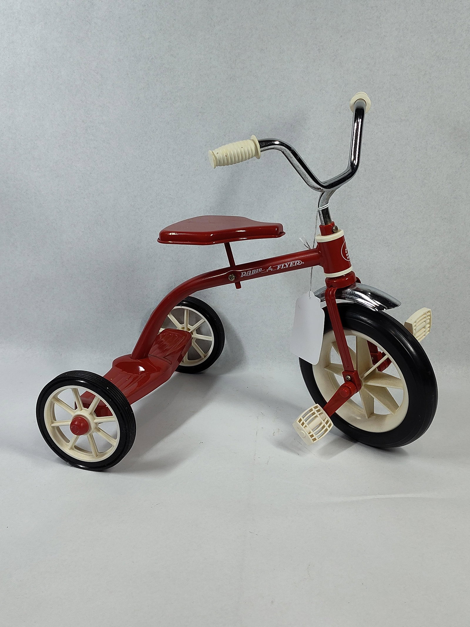 Radio Flyer Metal Doll Tricycle: 12x10x12 Radio Flyer authentic working miniature tricycle. The item is constructed with a red painted steel frame, chrome-plated handlebars, and a chrome-plated front fender. The side of the frame