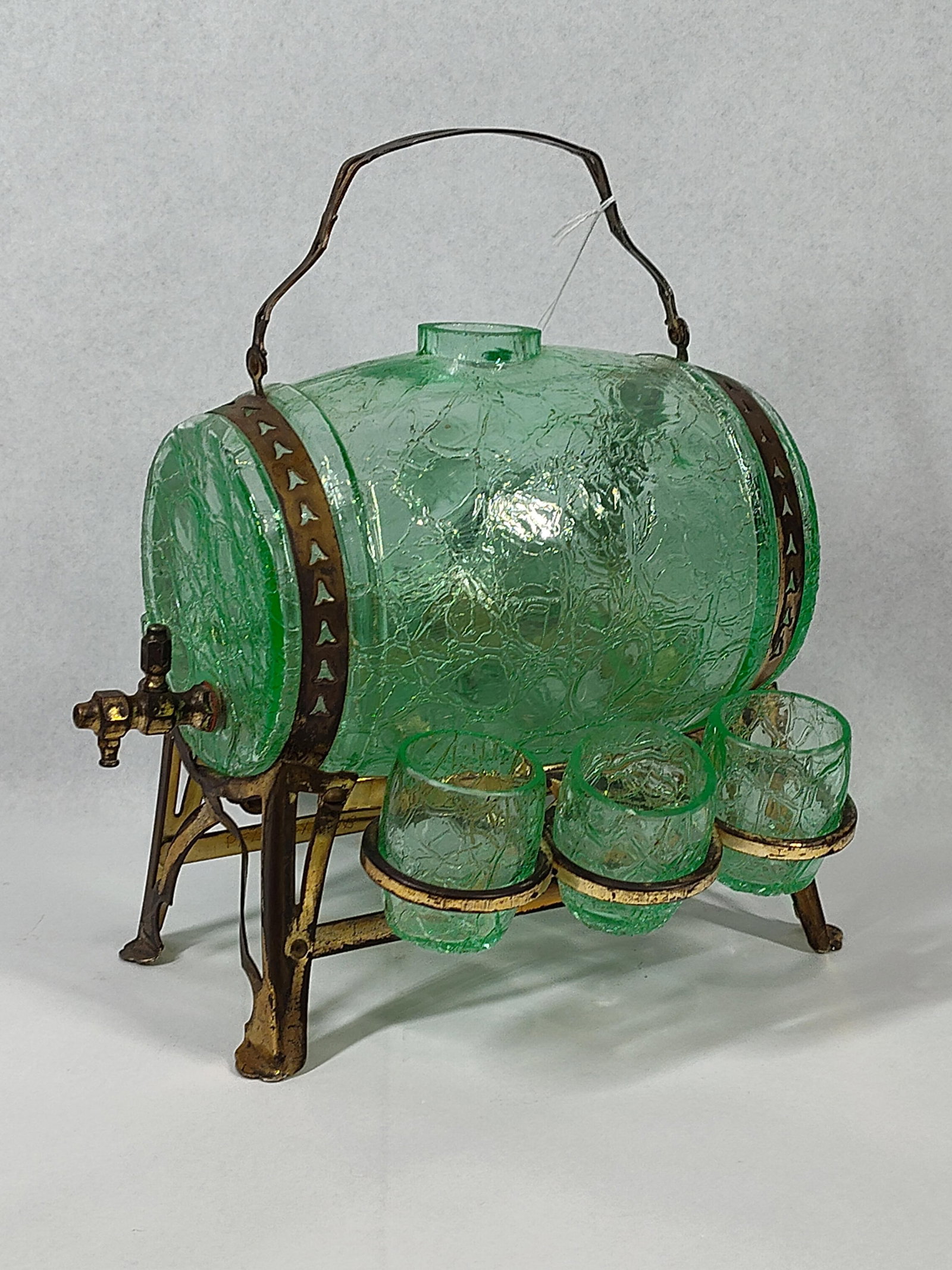 Uranium Crackle Glass Barrel Liquor Set: 5x4x5 This cordial or liqueur service is composed of a barrel-form vessel and six matching glasses crafted from green crackle glass. The glass features a characteristic textured finish achieved by plu