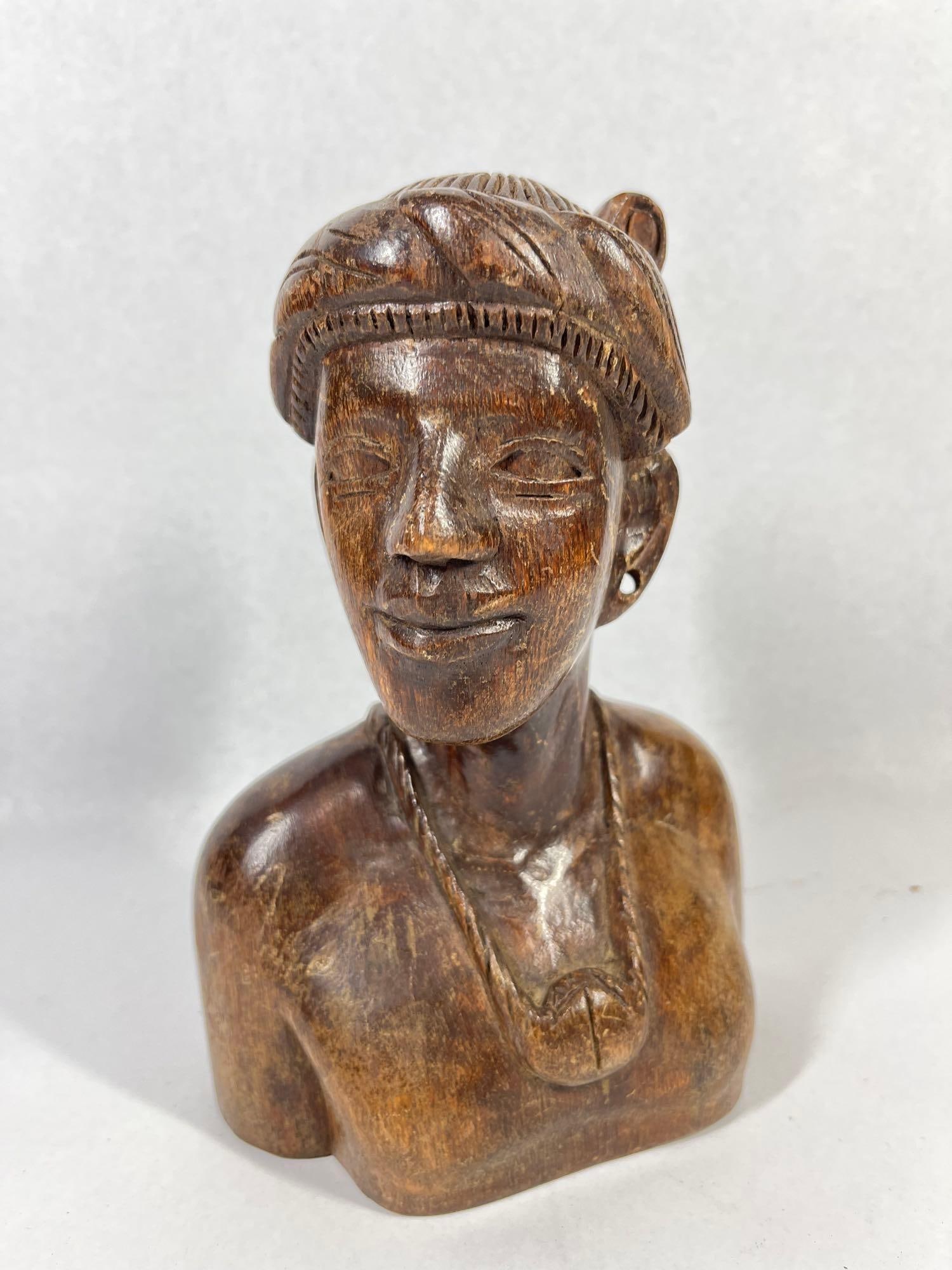 Mid-C. Carved Wood Female Tribal Bust: 9 inches. This is a hand-carved wooden bust of a female figure, likely dating from the mid-20th century. The sculpture is finished in a dark brown stain with a polished surface. The figure features al