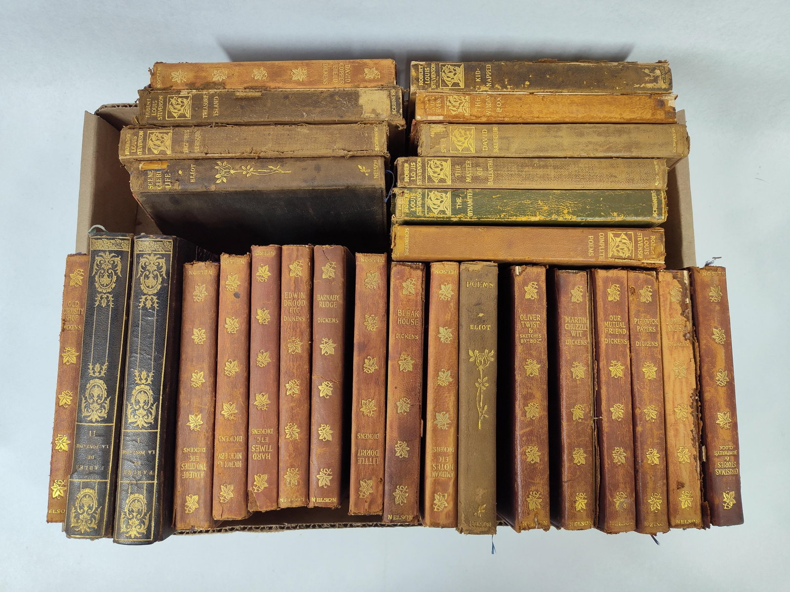 Dickens, Stevenson & Others: Volumes: A collection of antique and vintage literature volumes primarily comprising the works of Charles Dickens, Robert Louis Stevenson, and George Eliot. The collection features numerous titles from the New