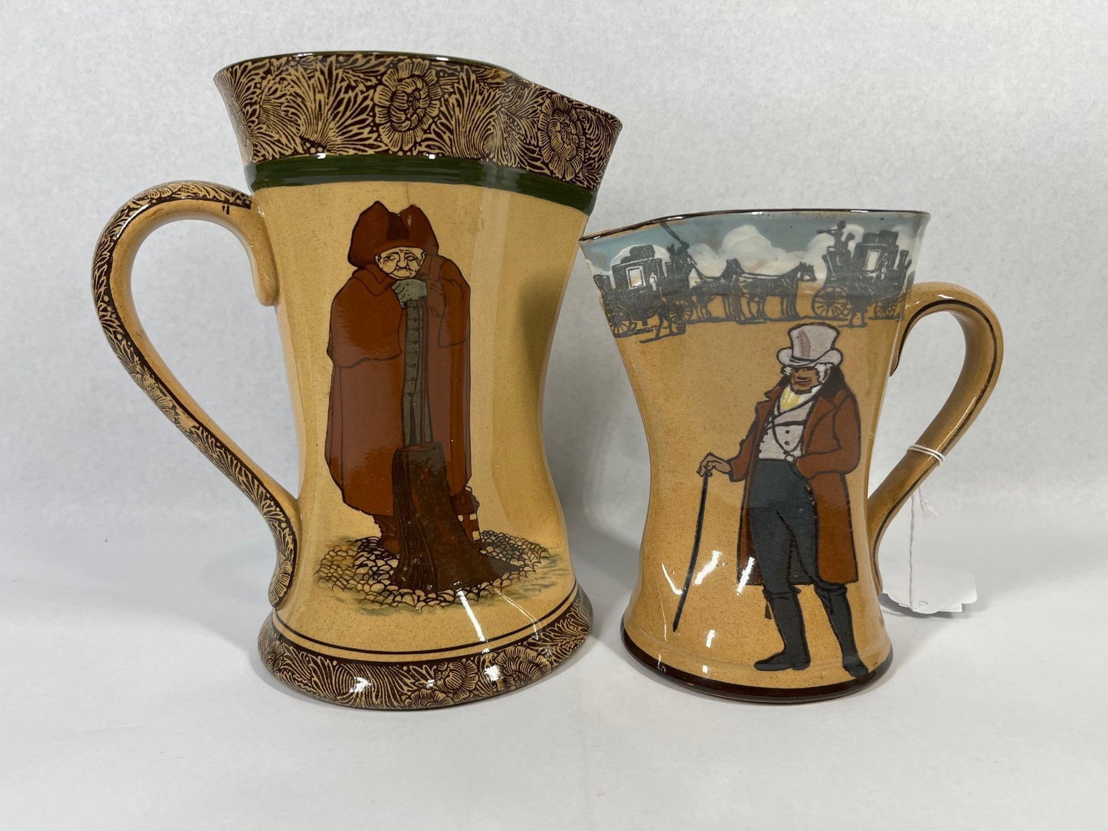 Royal Doulton Watchman & Coach Pitchers: 7 and 9 inches tall. Pitcher 8 inches.Two Royal Doulton glazed earthenware pitchers in the manufacturer's Series Ware line, dating to the early 20th century. Both vessels feature a waisted,