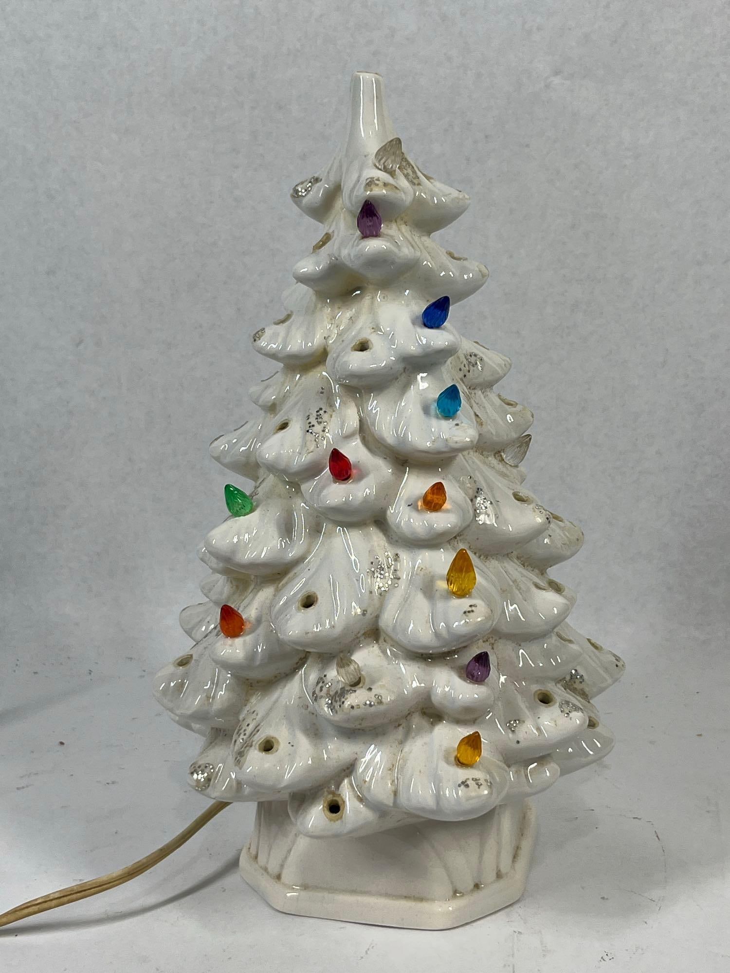 idescent Christmas Tree" is a better: 10 in. Attributed to Atlantic Mold, this vintage two-piece illuminated ceramic Christmas tree features a tiered evergreen design with a white iridescent mother-of-pearl glaze. The branch tips are