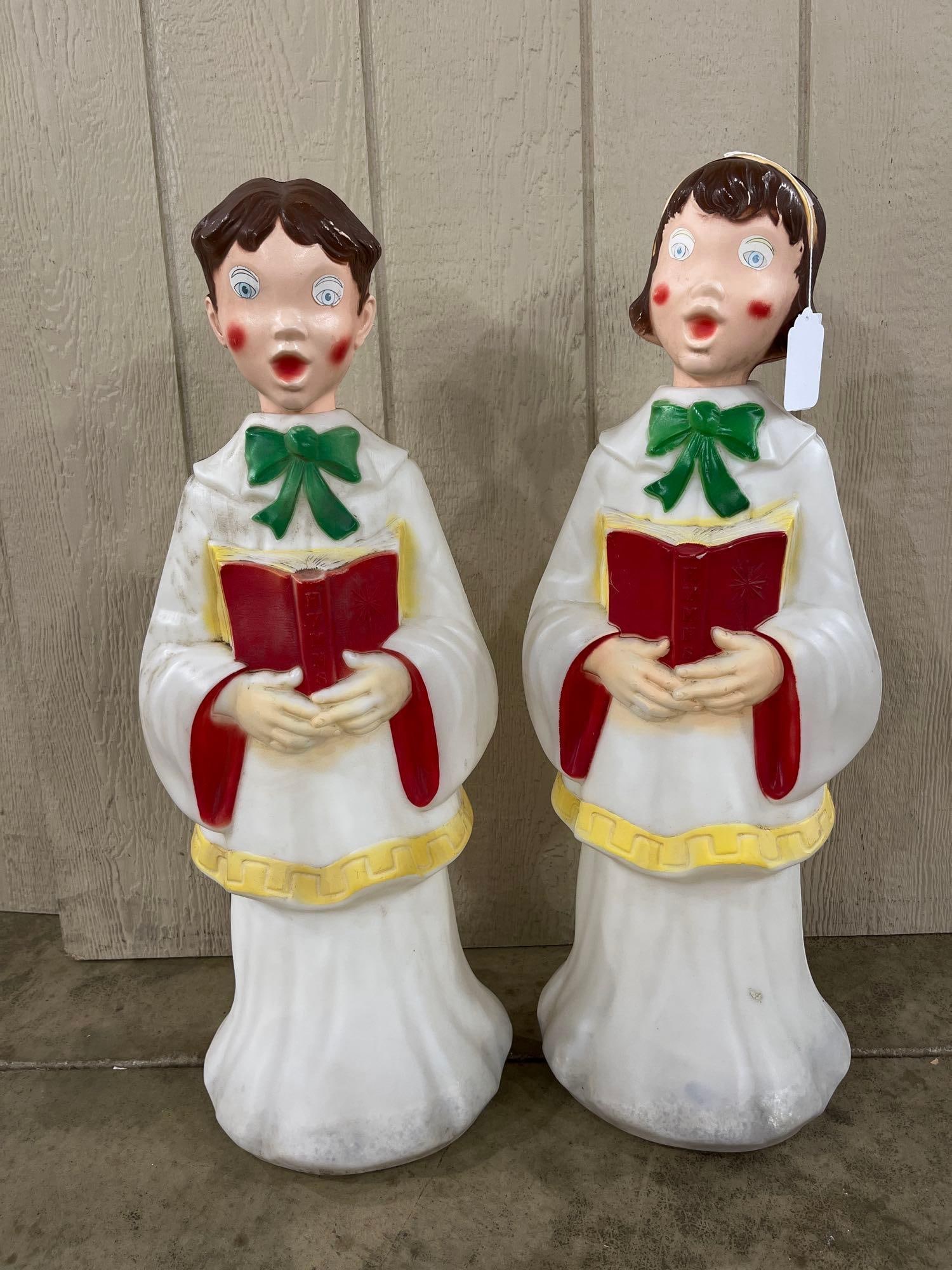Pair Empire Christmas Choir Blow Molds: 31 in. A pair of vintage blow-molded plastic Christmas caroler decorations produced by Empire Plastic Corp. of Tarboro, North Carolina. The set includes one boy and one girl choir singer, each