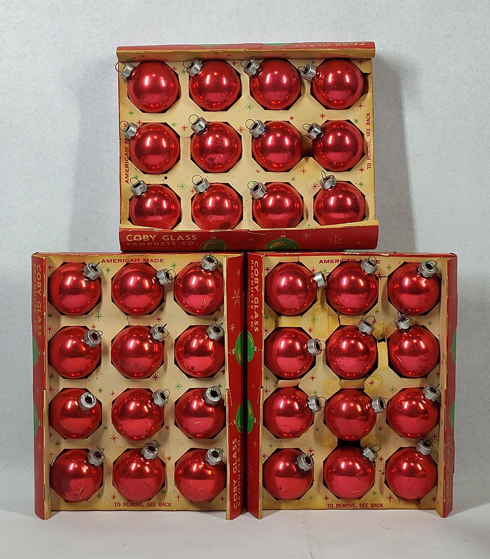 Vtg Coby Glass Red Christmas Ornaments: A collection of vintage red glass spherical Christmas ornaments produced by Coby Glass Products Co. based in Woonsocket, Rhode Island. Each ornament is constructed of red-colored glass and is fitted
