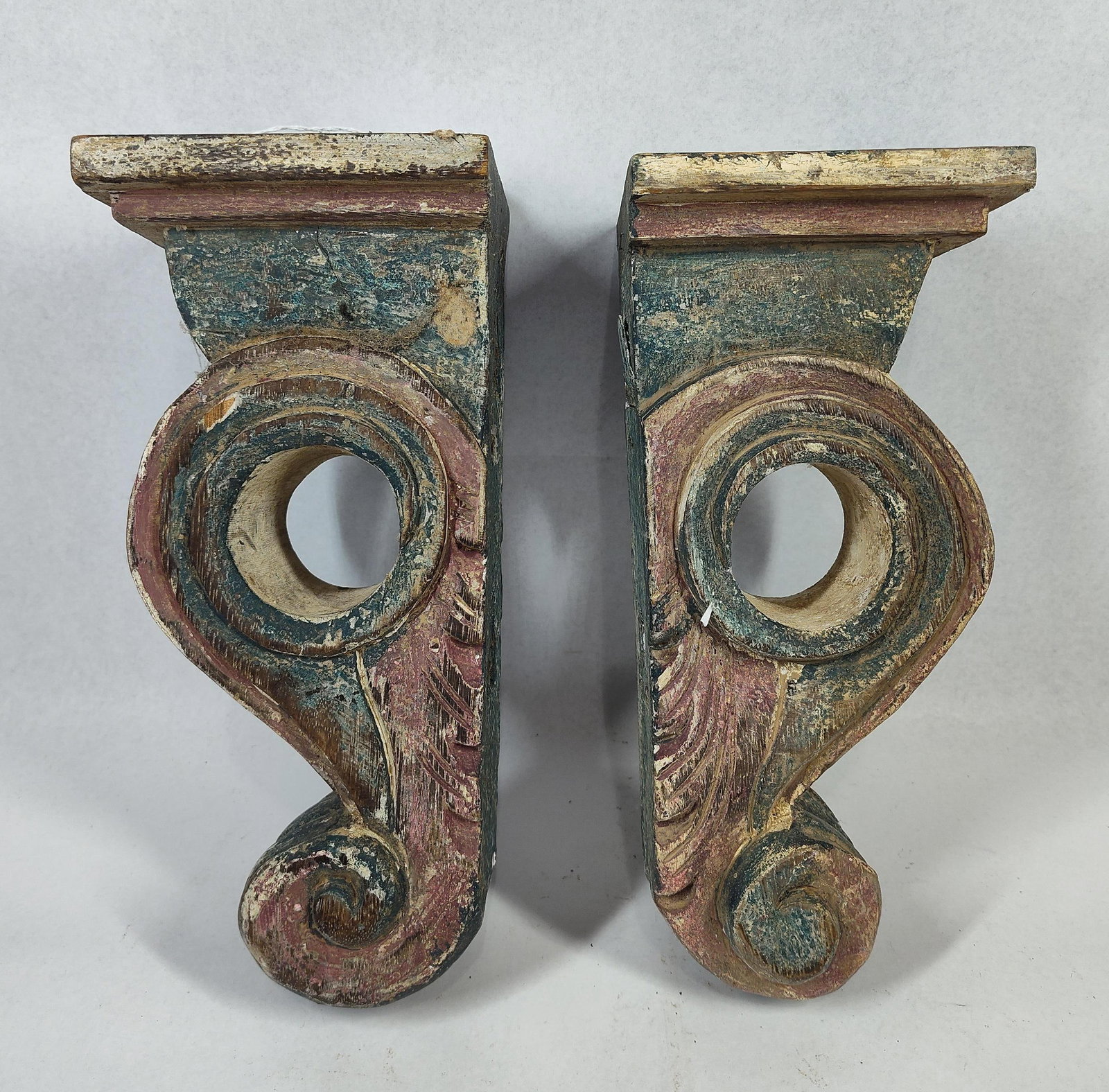 Pair Hand-Carved Polychrome Corbels: 11x4.5x5 A pair of hand-carved wooden architectural corbels or brackets with a polychrome painted finish. The design features a traditional S-scroll volute profile with a central circular cutout.