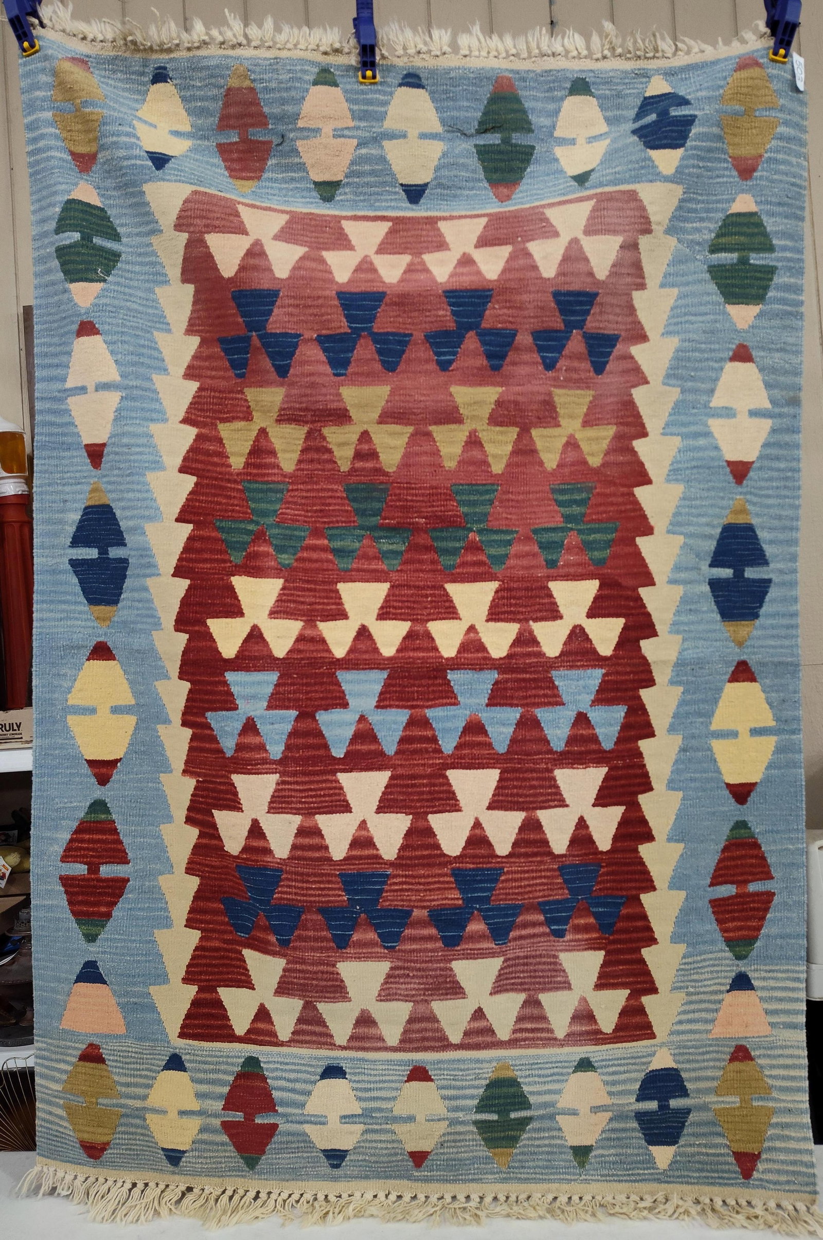 Turkish Handwoven Wool Kilim Rug: 50x72 Rug. This handwoven flat-weave kilim rug is composed of wool and features a design characteristic of Turkish Oushak styles. The rug displays a central terracotta red field decorated with horizon
