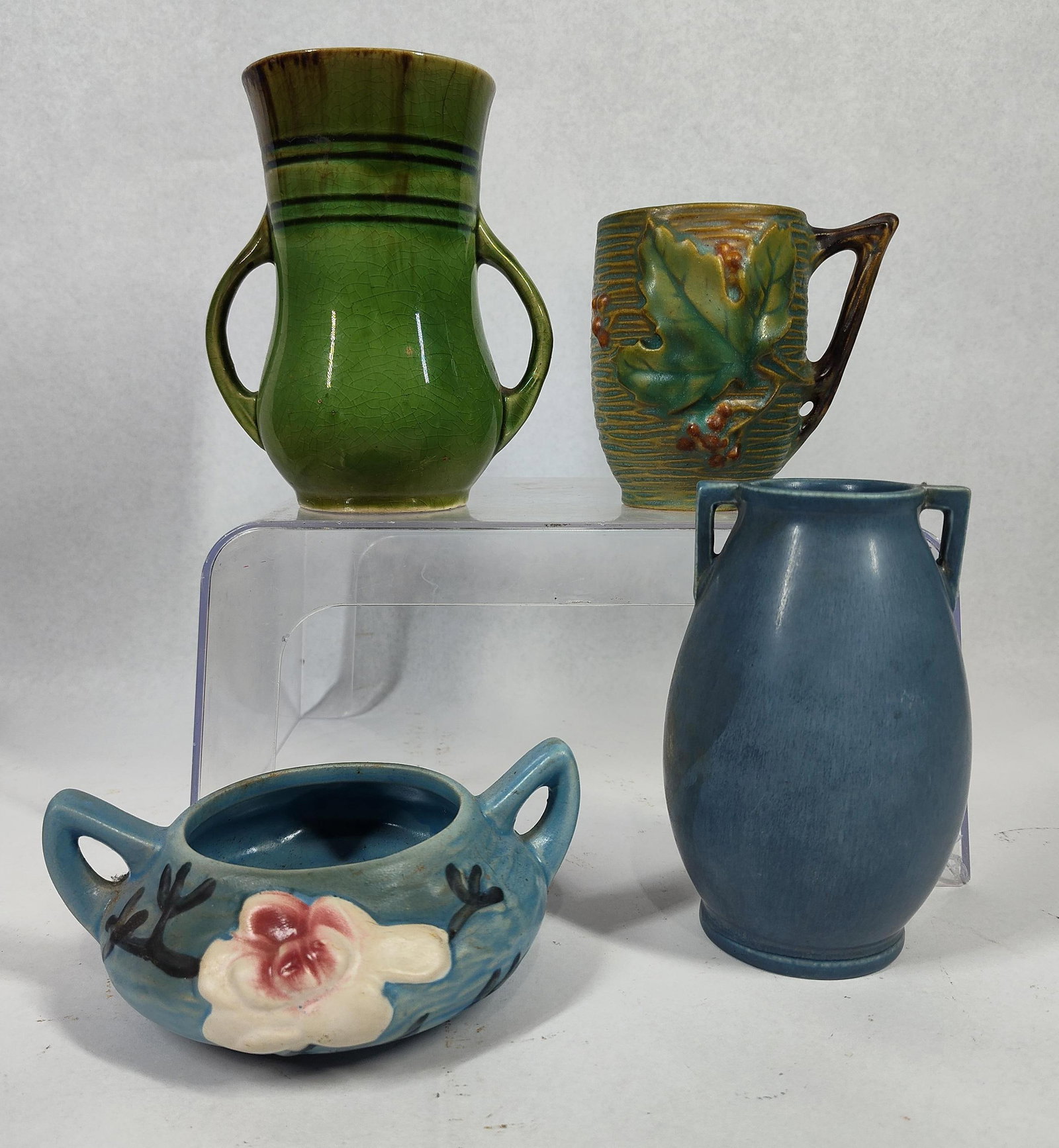 American & Japanese Art Pottery: 2, 4, and 5 inches. This assortment consists of art pottery from American and Japanese manufacturers. The collection includes a Rookwood Pottery matte blue vase with an ovoid body and two square-set