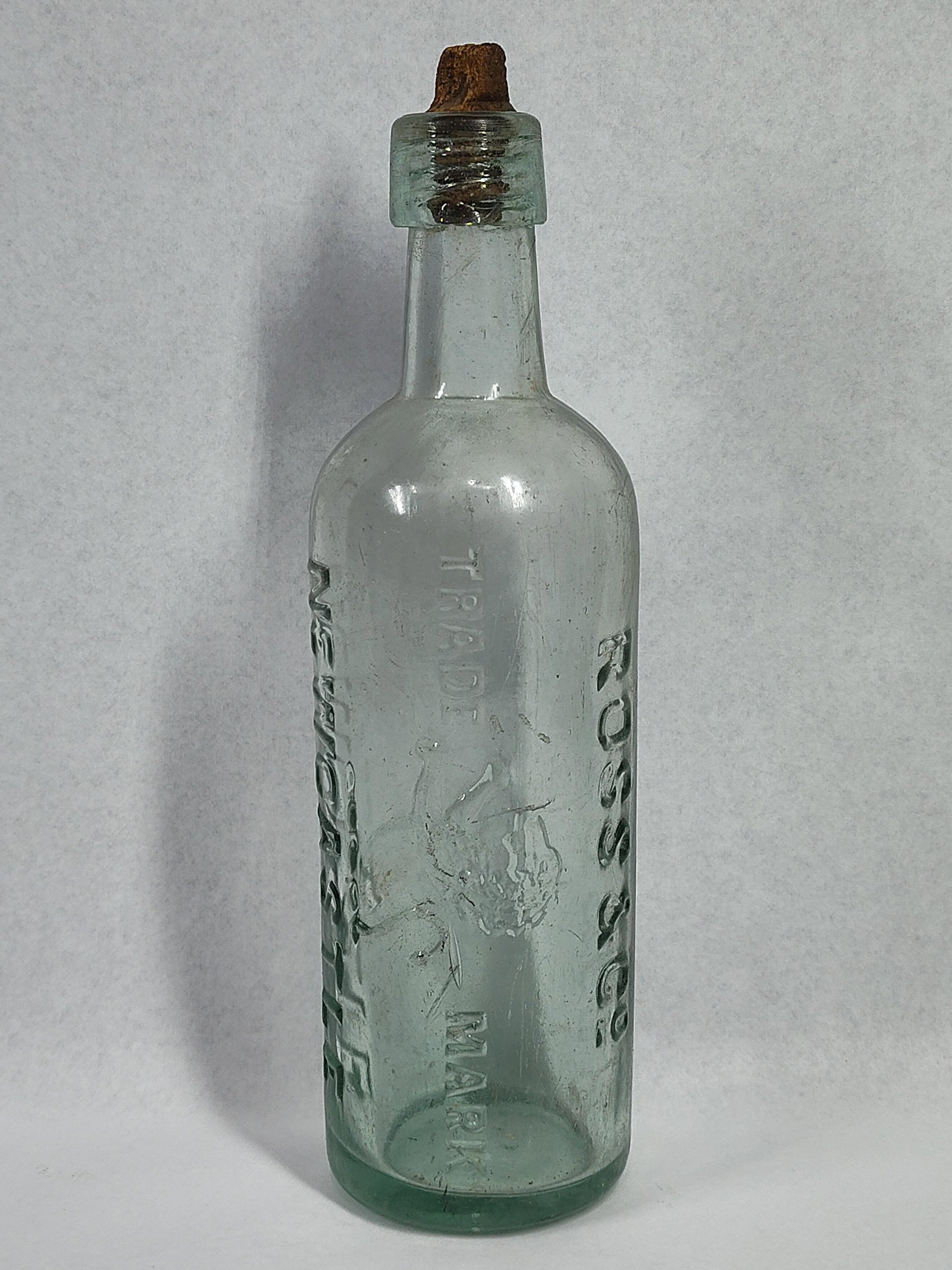 Ross & Co Newcastle Aqua Mineral Bottle: 10 inches.This antique aqua-toned glass bottle features prominent vertical embossing. On one side, the vessel is embossed with the name ROSS & CO, while the opposite side bears the location