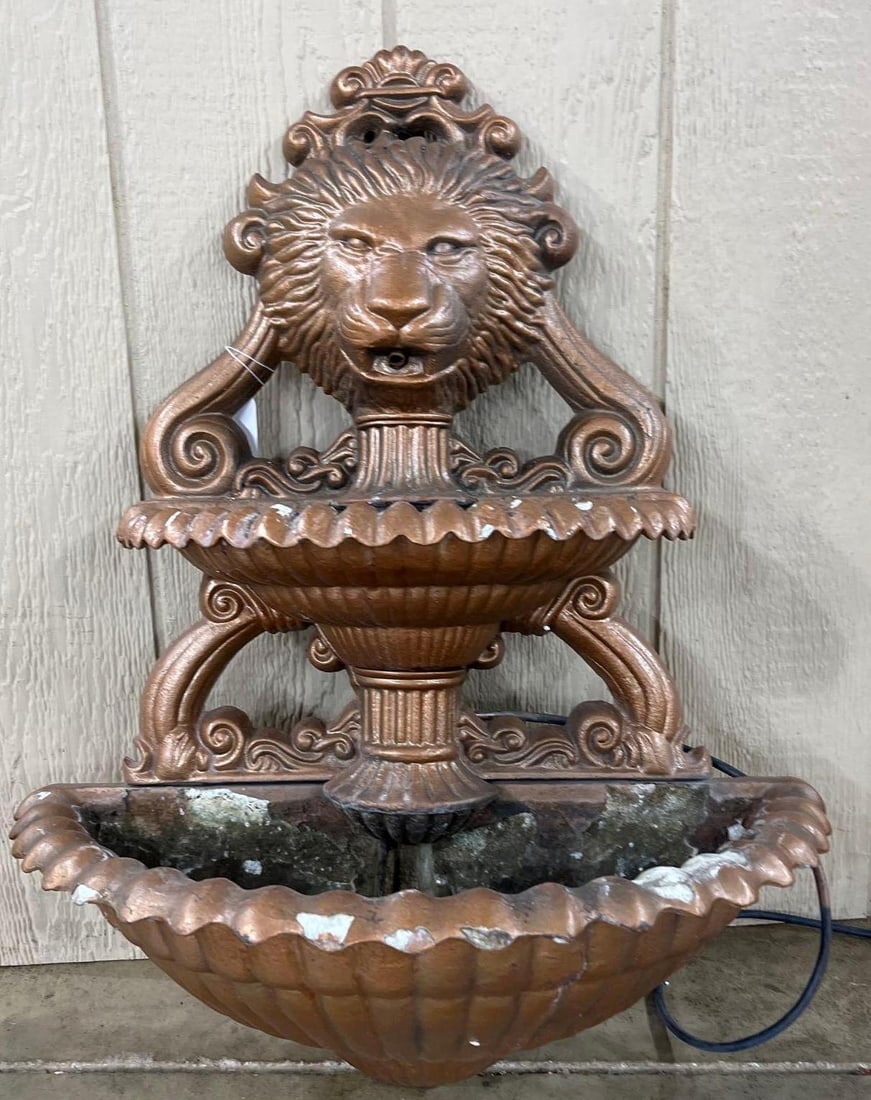 Neoclassical Lion Head Wall Fountain: 27x24 A wall-mounted two-tier fountain designed in the Neoclassical style. The piece is constructed from a cast composite material with a metallic copper and bronze-toned lacquer finish. The upper