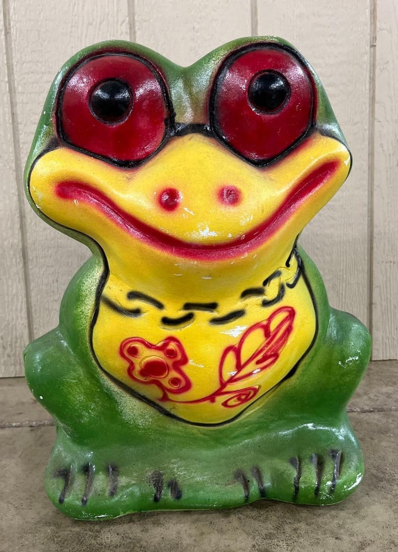 Mid-20th C. Chalkware Frog Coin Bank: 19 inches. A novelty coin bank in the form of a stylized sitting frog, constructed of hand-painted chalkware or heavy plaster. The figure features an expressive face with oversized red eyes, black