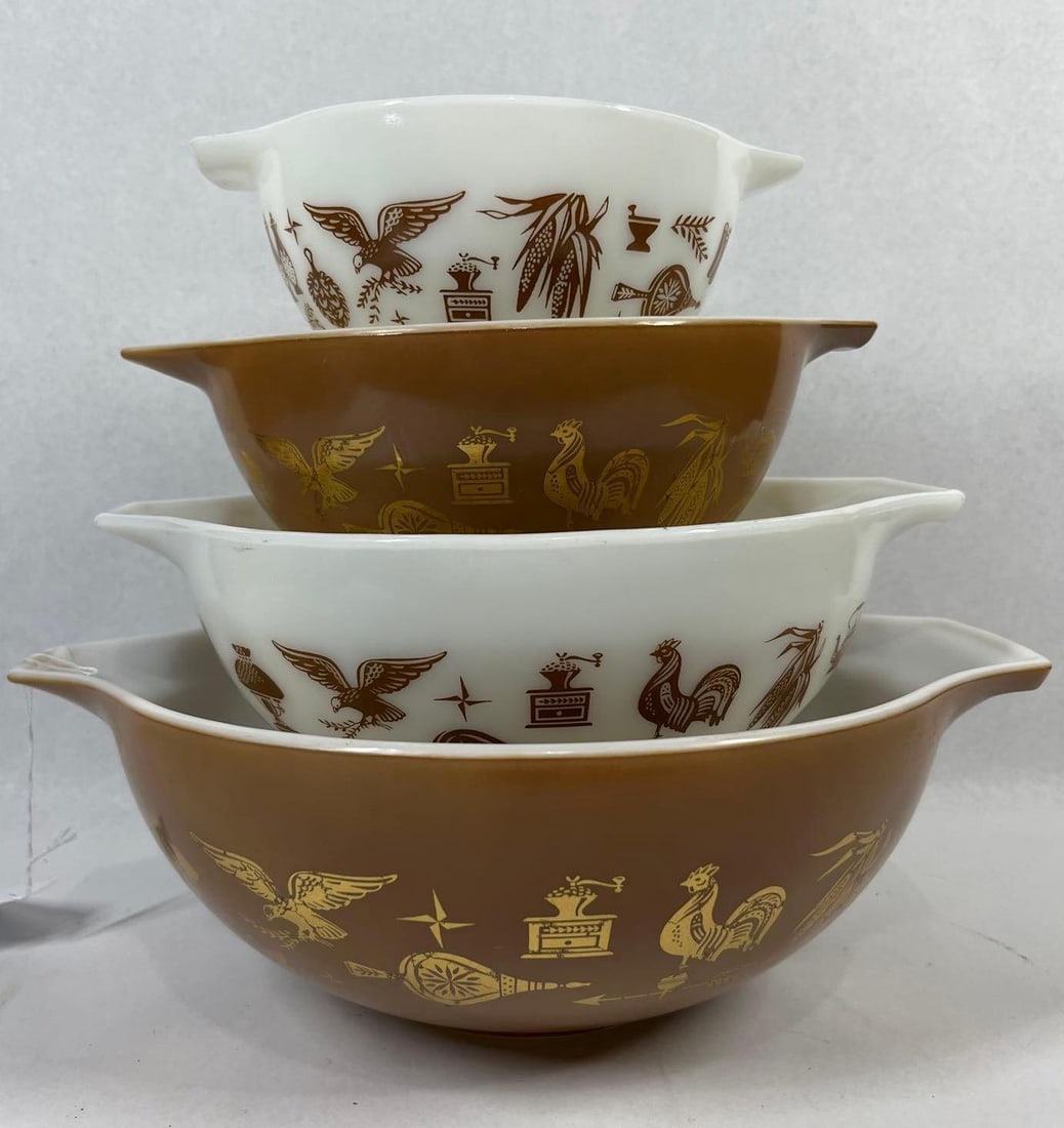 Set 4 Pyrex Early American Mixing Bowls: A set of four vintage Pyrex nesting mixing bowls in the Cinderella style, featuring the Early American pattern. The collection is crafted from white opal glass and features an alternating color