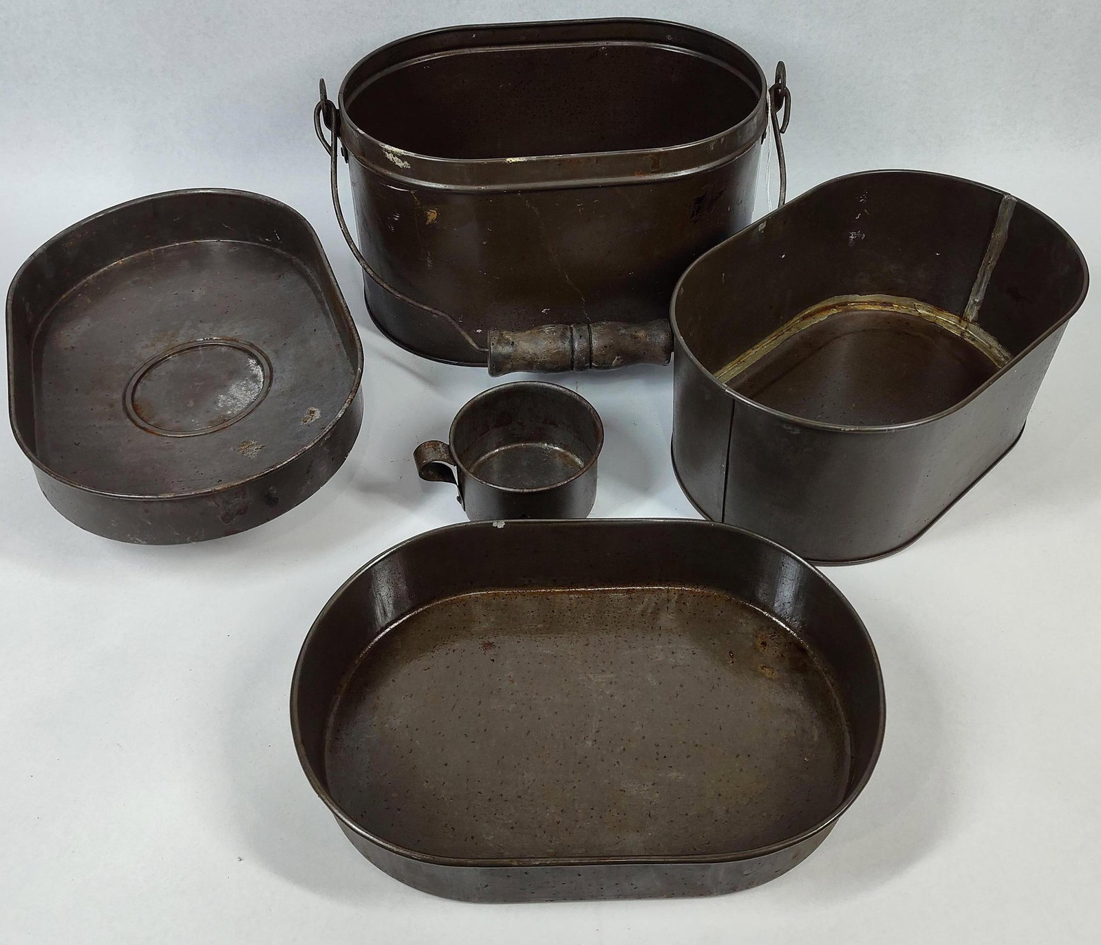 5-Pc Stackable Metal Miner's Lunch Pail: 10x6.5x9 This lot comprises an antique five-piece stackable metal lunch kit, traditionally utilized by industrial laborers such as miners and railroad workers during the late 19th and early 20th