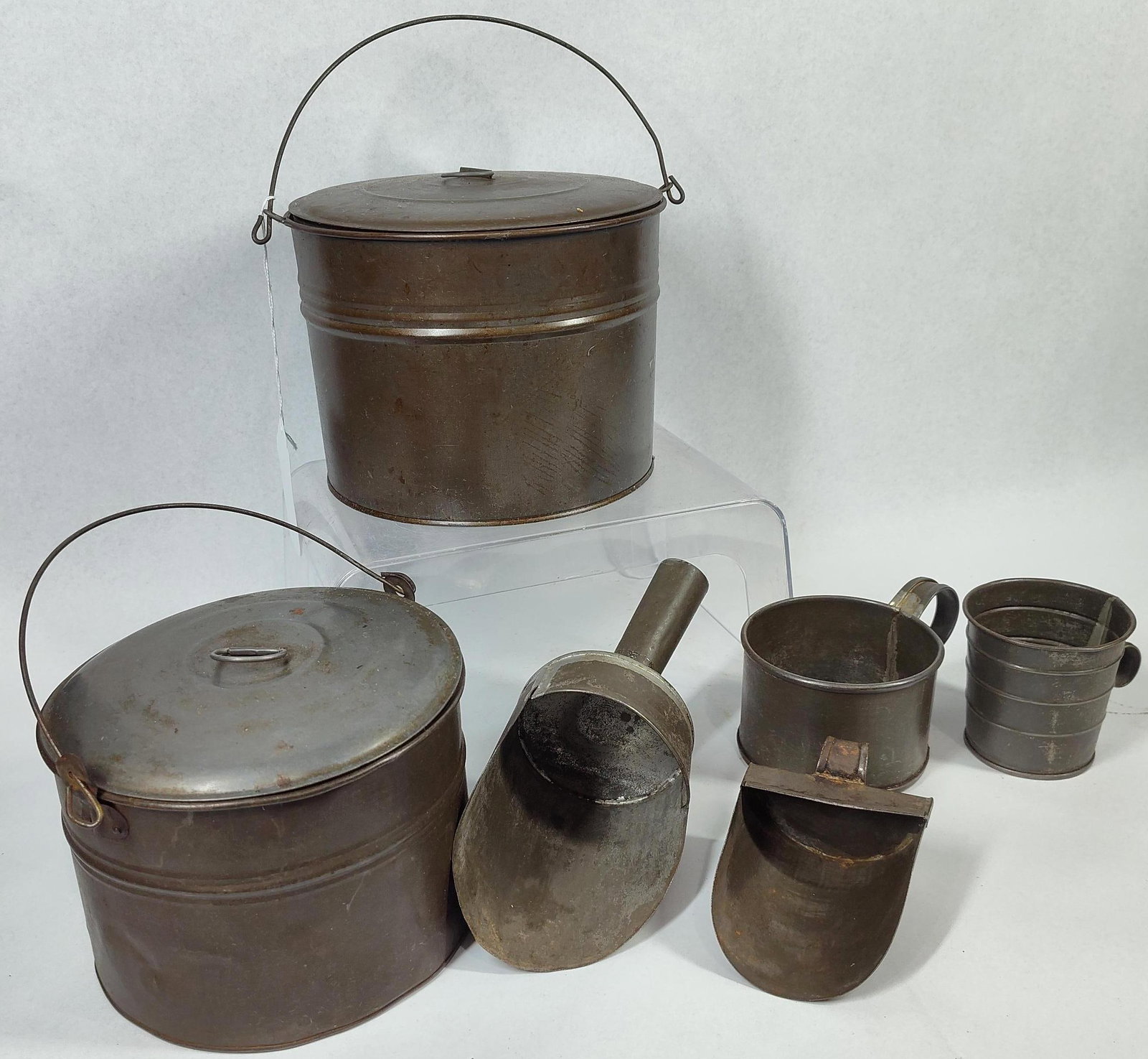 Antique & Vtg Kitchen & Utility Tinware: A collection of American tinware consisting of items typical of 19th to early 20th-century farmhouse kitchens and general stores. The assortment includes cylindrical lidded pails, utility scoops, and