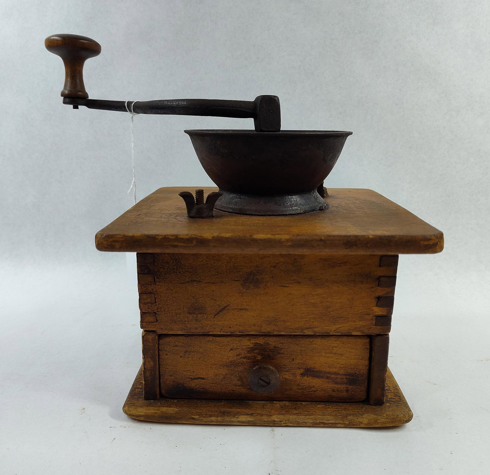 Antique Wood & Cast Iron Coffee Grinder: 8x8x8 This is an antique manual box-style grinder used for processing coffee beans or spices. The object features a square wooden body constructed with finger-jointed corners, mounted on a wide, flare