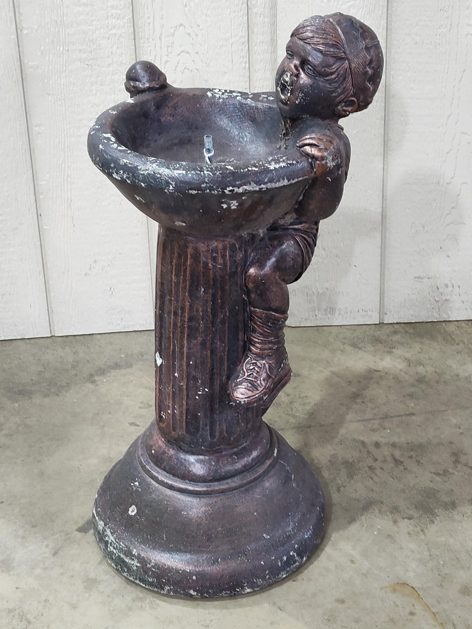 Henri Studio Cast Stone Boy Fountain: This vintage cast stone garden fountain was manufactured by Henri Studio Inc. in 1976. The piece features a sculptural depiction of a young boy in mid-climb, peering into a shallow, circular basin. Th