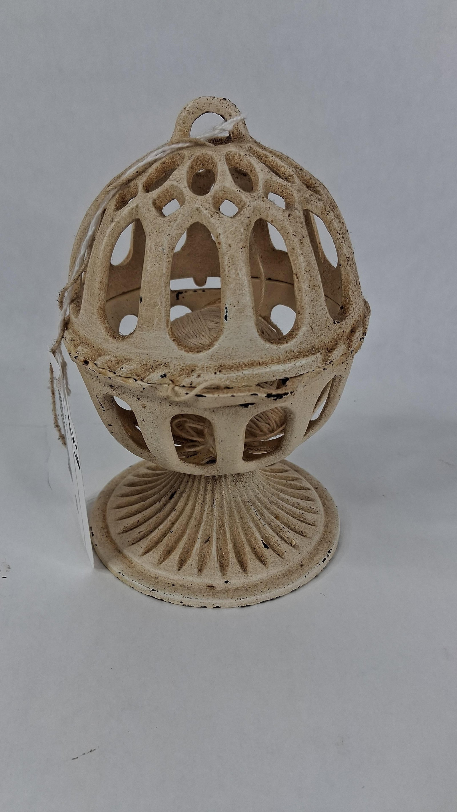 Cast Iron Pedestal Twine Ball Holder: .5 in tallA decorative cast iron tabletop twine or string dispenser designed in a Victorian revival style. The object features a two-part spherical cage with repeating arched open-work piercings. The