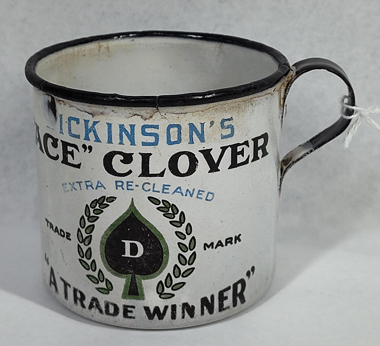 Dickinson's Seed Advertising Enamel Mug: 2.5x3 A advertising porcelain enamelware mug promoting The Albert Dickinson Company seed products. The cup is constructed of steel with a white porcelain enamel finish featuring a black rim and
