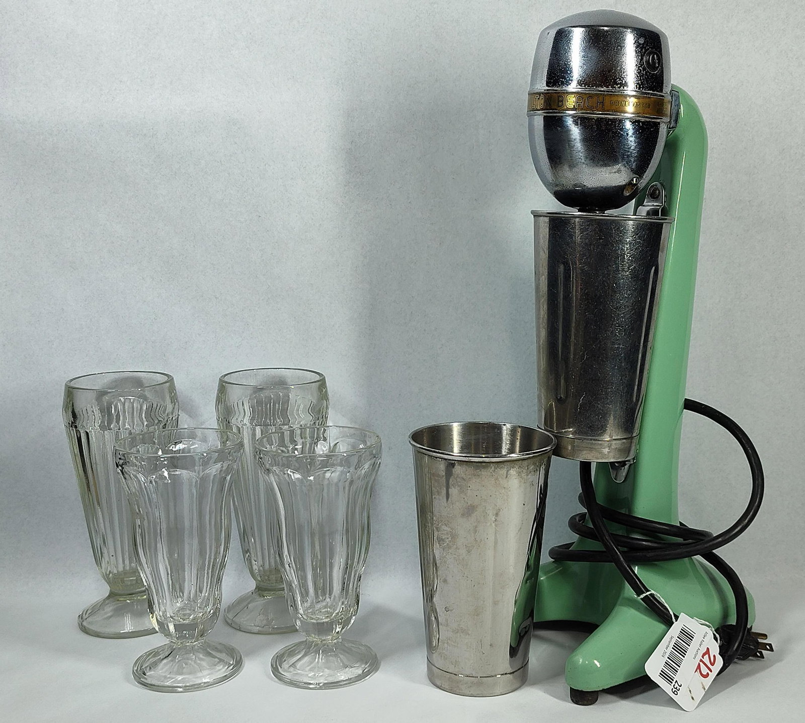 Hamilton Beach Drinkmaster No. 30 Mixer: A set comprising one Hamilton Beach Number Thirty Drinkmaster electric drink mixer, two stainless steel mixing cups, and four fluted glass serving vessels. The mixer is constructed with a cast metal s