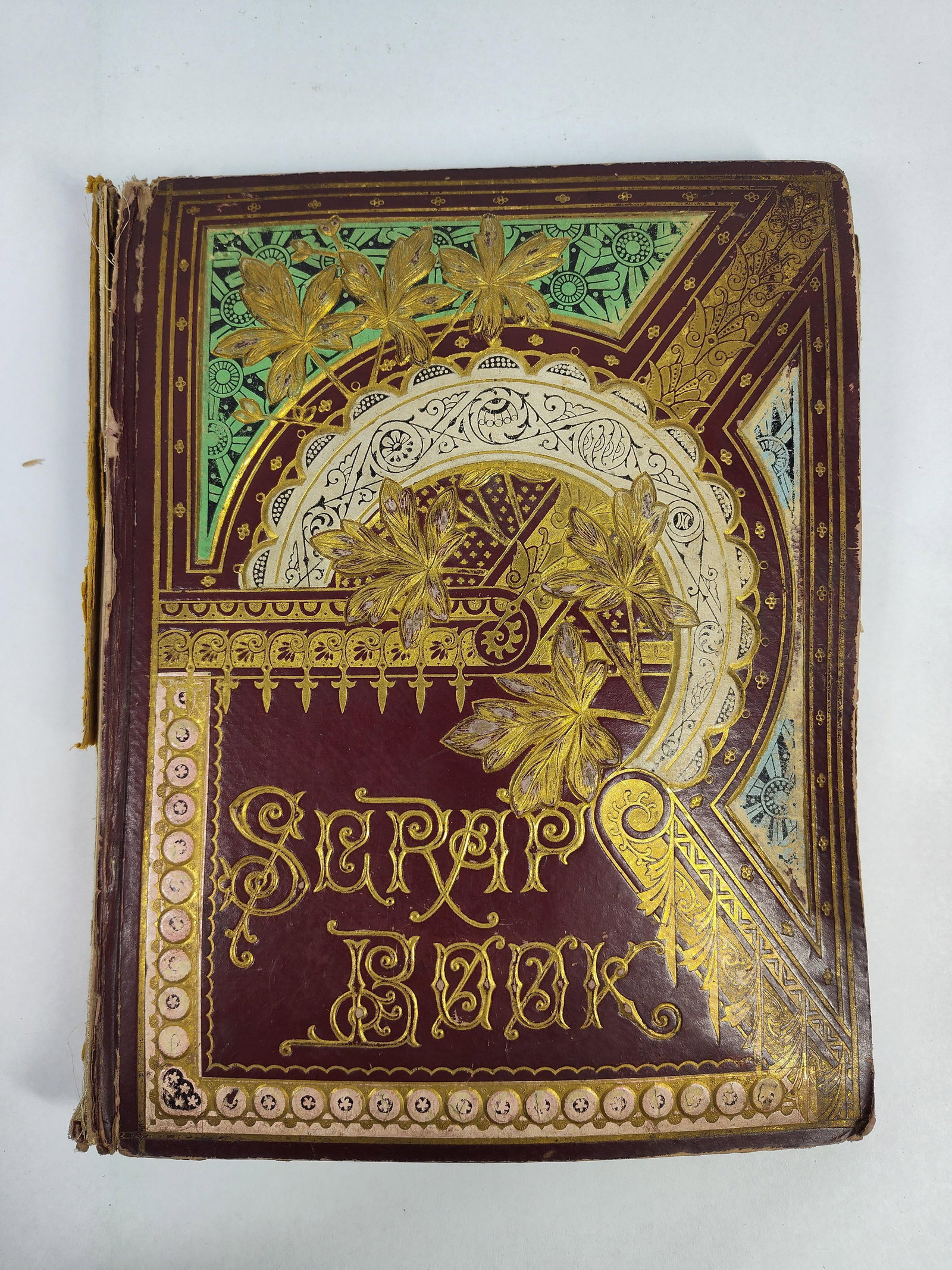 Ohio Trade Card Scrapbook c. 1884-1886: A late 19th-century quarto-sized scrapbook containing an assortment of chromolithographed trade cards and lithographs. The album is bound in maroon textured cloth with elaborate gilt and polychrome em