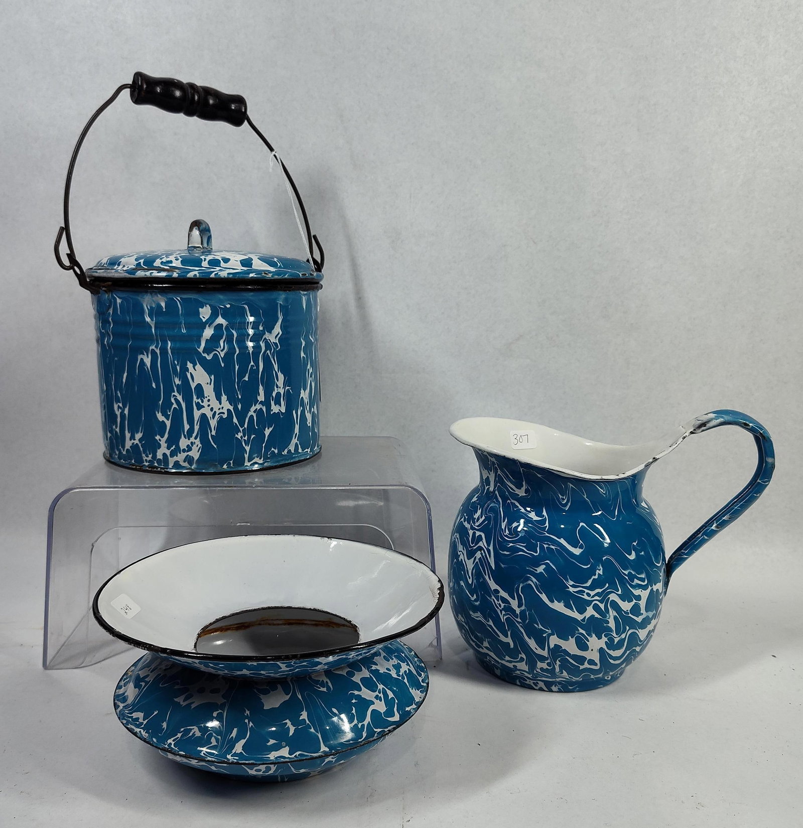 3-Pc Blue & White Marbled Graniteware: A trio of blue and white marbled agateware items featuring an enameled steel construction. The group consists of a lidded bucket or pail, a pitcher, and a two-piece soap dish. The bucket is designed