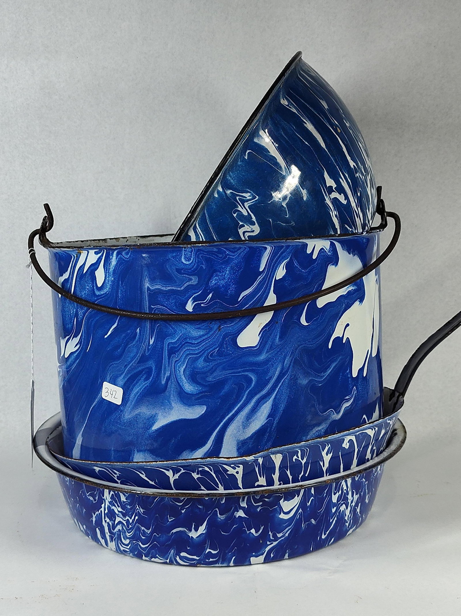 Set Cobalt & White Swirl Graniteware: This set of utilitarian kitchen items is constructed from enamel-coated metal, featuring a classic cobalt blue and white swirl pattern commonly referred to as graniteware or agateware. The collection