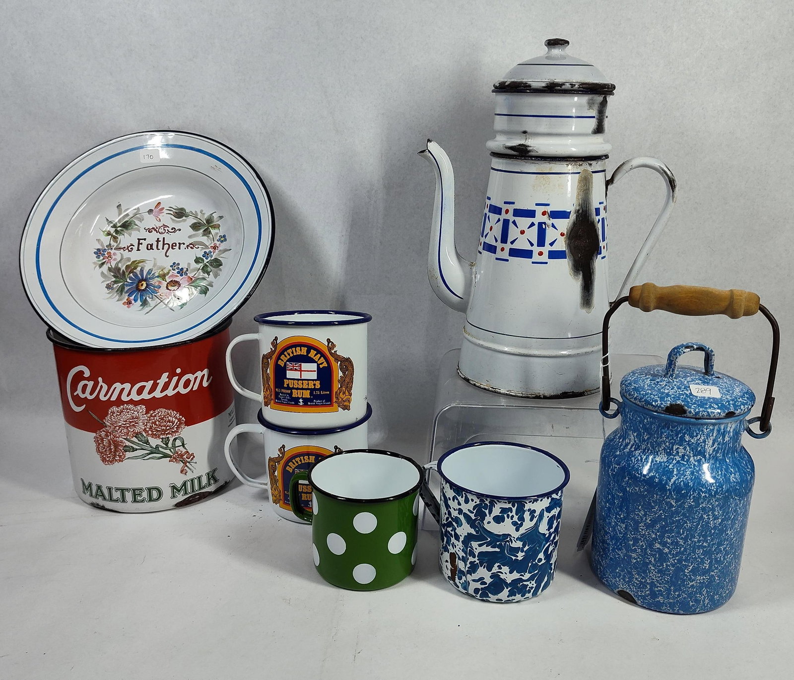 Advertising & Decorative Enamelware: This lot contains an assortment of enamelware on steel featuring commercial advertising, maritime themes, and decorative patterns. A primary item is a large cylindrical Carnation Malted Milk advertisi