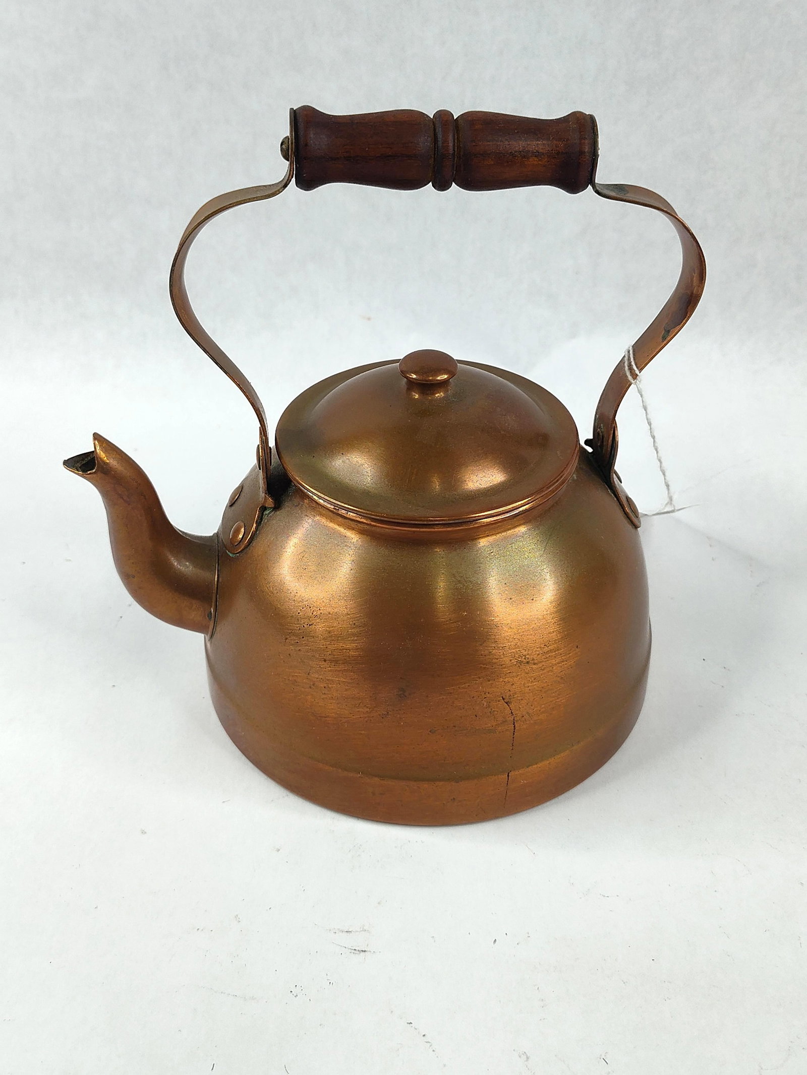 Tagus Portuguese Copper Tea Kettle: This copper tea kettle was manufactured by Tagus in Portugal. The piece is constructed from formed sheet copper and features a traditional bulbous body with a fitted lid and a copper knob. The handle