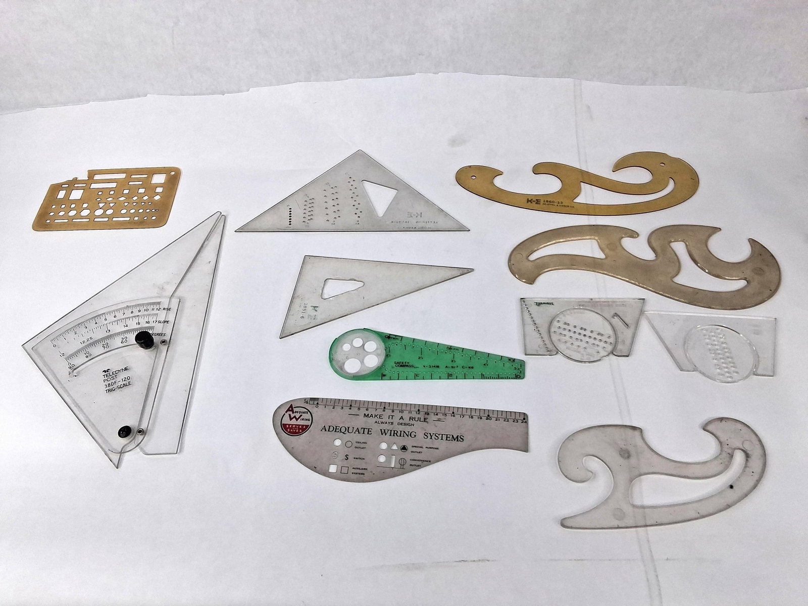 Keuffel & Esser & Teledyne Post Tools: An assortment of eleven drafting and engineering instruments and templates from various manufacturers. The collection includes a Teledyne Post adjustable trig-scale triangle, model 38DF-120, featuring
