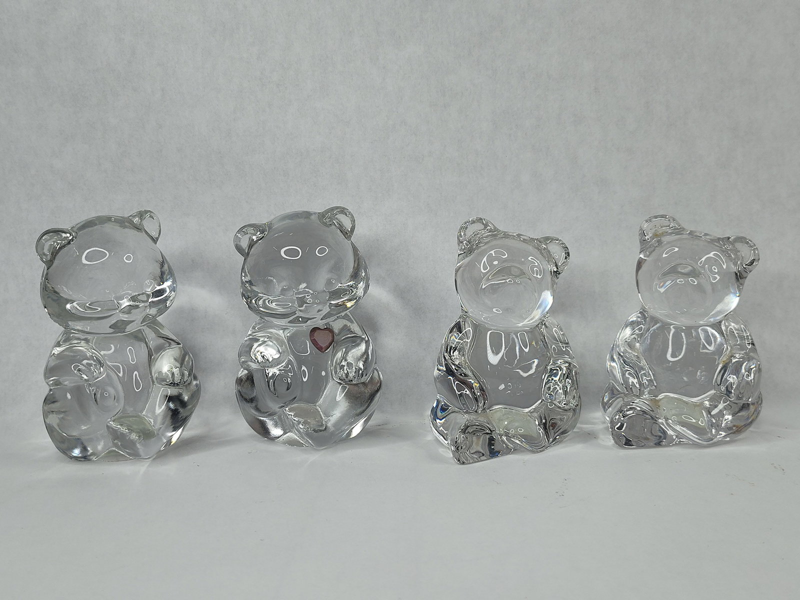Set 4 Fenton Clear Glass Bear Figurines: This collection consists of four molded clear glass figurines produced by the Fenton Art Glass Company. The group features two large sitting bears, commonly identified by collectors as the Papa Bear o