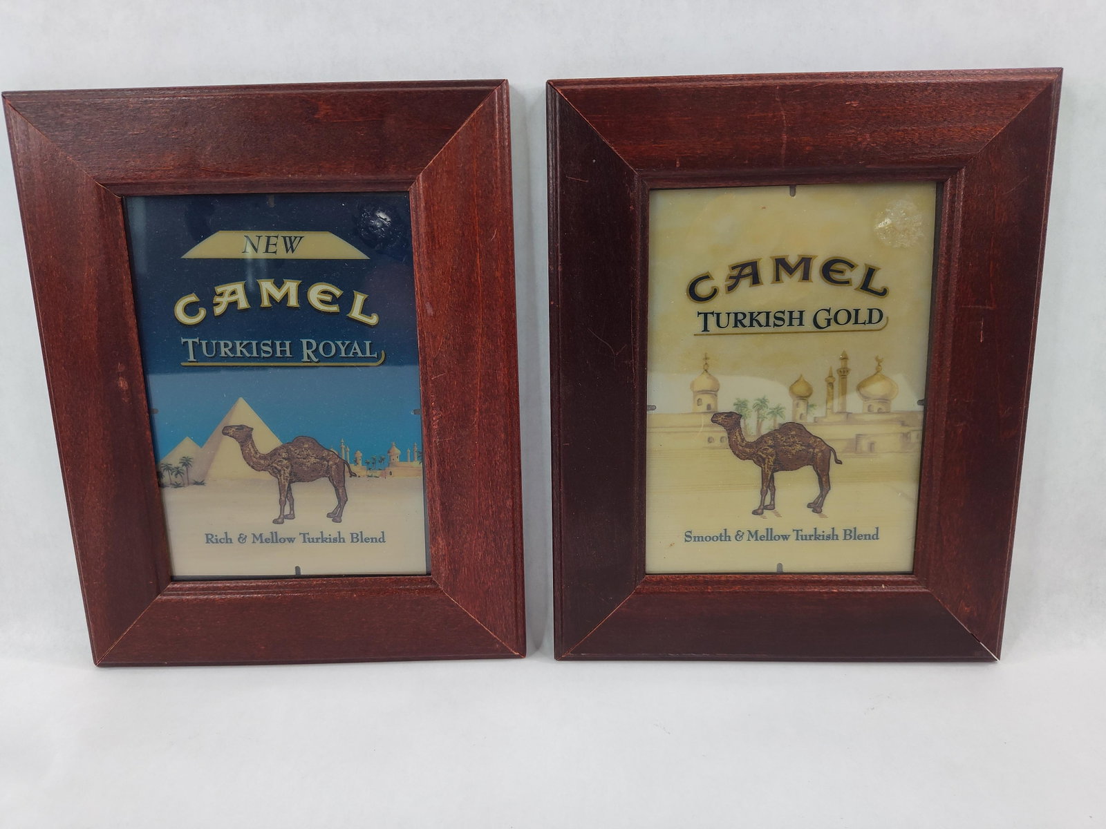 Pair Camel Turkish Royal & Gold Ads: This lot consists of a pair of framed promotional advertisements for Camel brand cigarettes, produced by the R.J. Reynolds Tobacco Company. The set includes one display for the Turkish Royal variant a