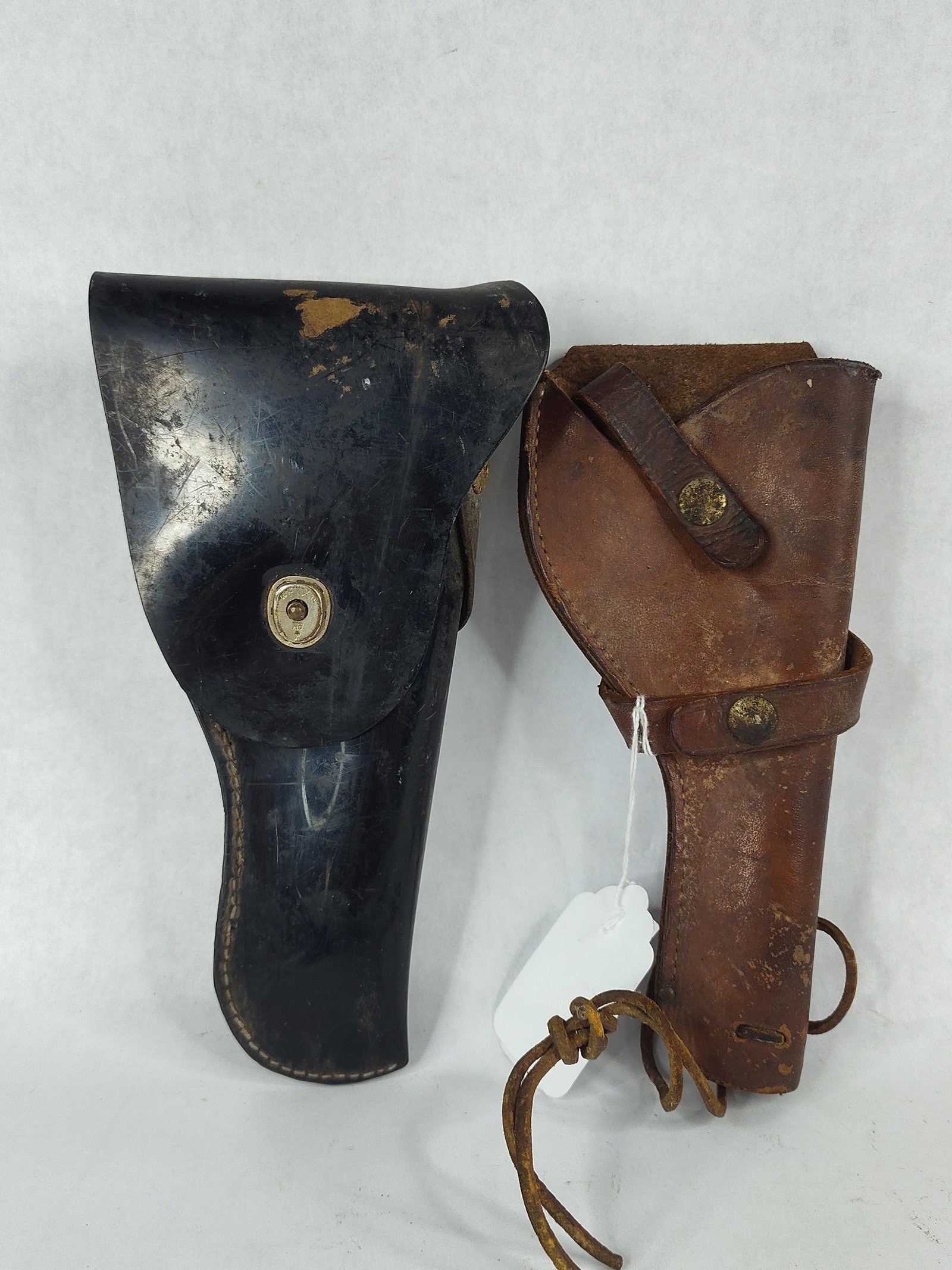 Pair Vtg Leather P08/Semi-Auto Holsters: A pair of mid-20th century leather pistol holsters. The first is a full-flap holster specifically contoured for a P08 Luger semi-automatic pistol. It is constructed from leather with a polished black 