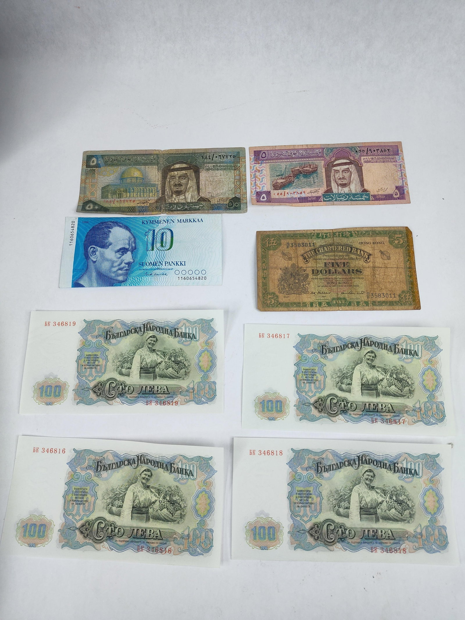 Consecutive Bulgarian & Hong Kong Notes: This group of international paper currency includes banknotes from Bulgaria, Finland, Saudi Arabia, and Hong Kong. The collection features four consecutive 100 Leva notes from the Bulgarian National