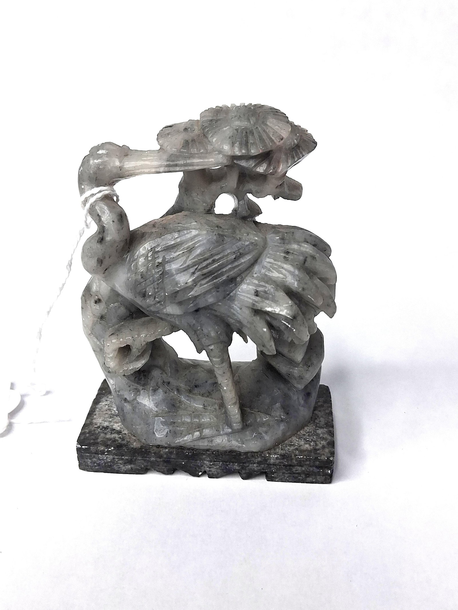 Chinese Soapstone Crane & Lotus Carving: A hand-carved soapstone figurine depicting a crane amidst lotus blossoms and foliage. The sculpture is fashioned from mottled light-gray soapstone featuring dark gray and black inclusions throughout.