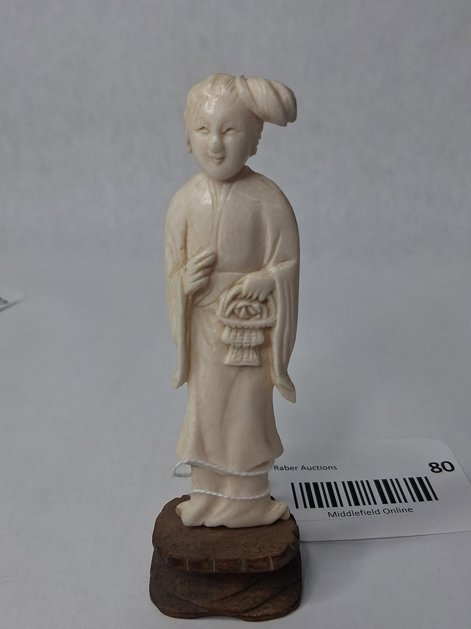 Chinese Bone/Ivory Woman Figurine: A hand-carved figurine of a standing female figure in traditional Chinese robes. The figure is depicted with a serene, smiling expression and an elaborate hairstyle featuring a large side bun. She is
