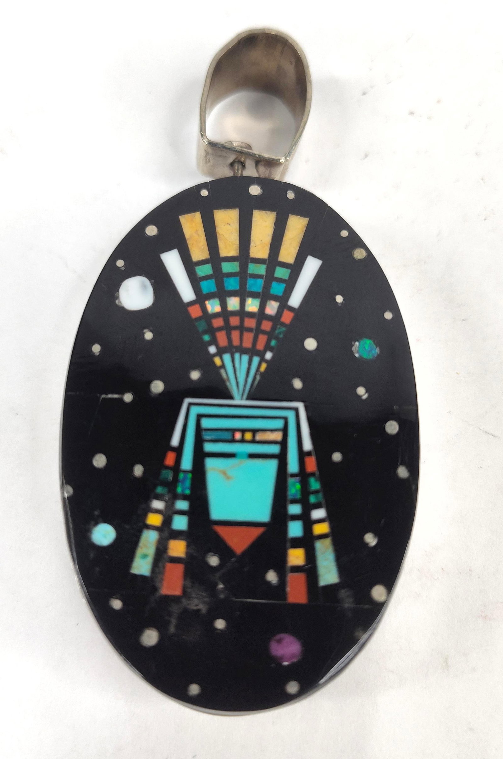 Navajo Str. Micro Inlay Kachina Pendant: A large Navajo reversible micro-inlay pendant featuring two distinct stone-inlaid faces set within a heavy silver bezel. One side depicts a pictorial scene of a Pueblo village under a starry night