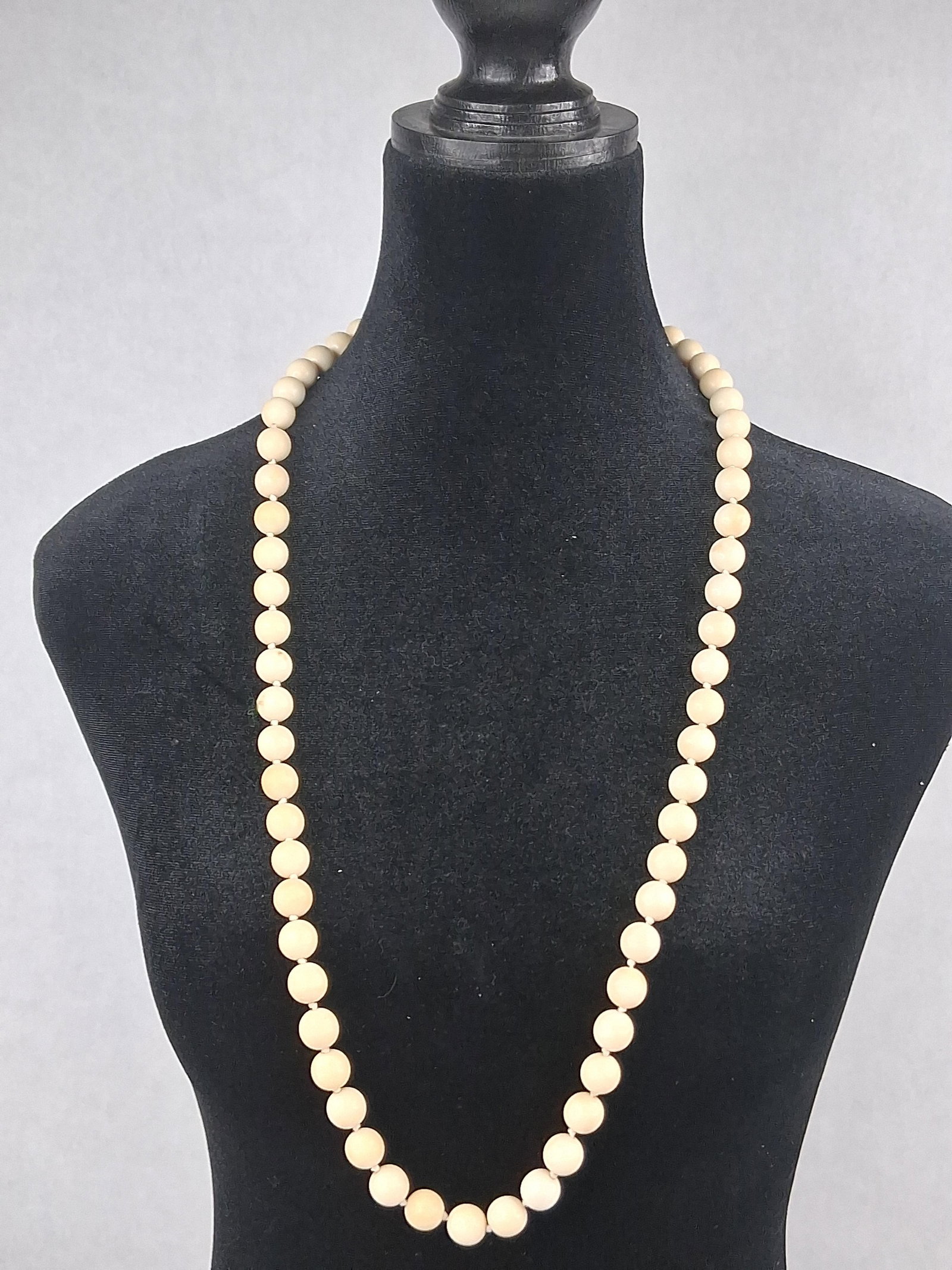 Vtg Hand-Knotted Bone Bead Necklace: A long beaded necklace featuring uniform round beads crafted from cream-colored bone or a similar natural material. The beads are individually hand-knotted on matching thread. The necklace terminates