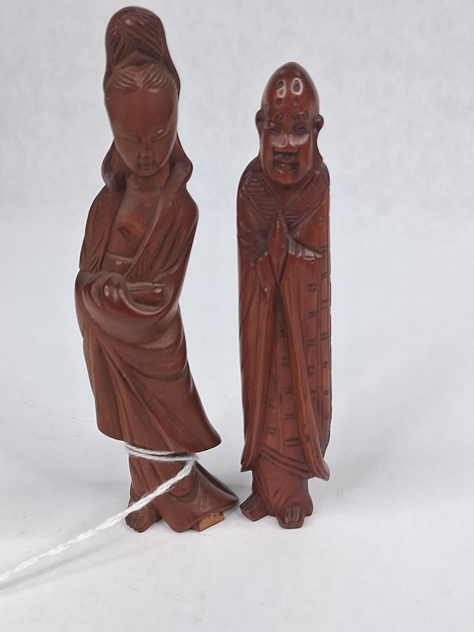 Two Chinese Carved Boxwood Figures: This lot features two Chinese hand-carved figures fashioned from boxwood with a rich reddish-brown patina. One figure represents a female personage with an elaborate high hairstyle and flowing,