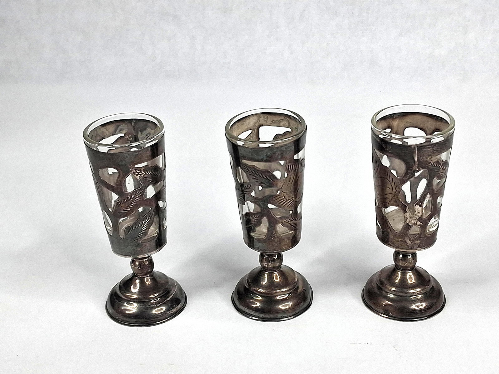Trio Thai Str. & Glass Pierced Cordials: This set of three footed cordial or shot glasses features removable clear glass liners set within decorative pierced sterling silver frames. Each frame is designed with a flared circular base and a