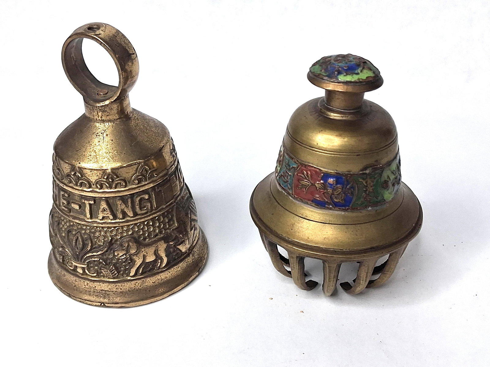 Vtg Brass Monastery & Enamel Claw Bells: This lot features two distinct decorative brass bells. The first is a cast brass monastery style bell featuring three horizontal registers of relief decoration. The top register contains a repeating