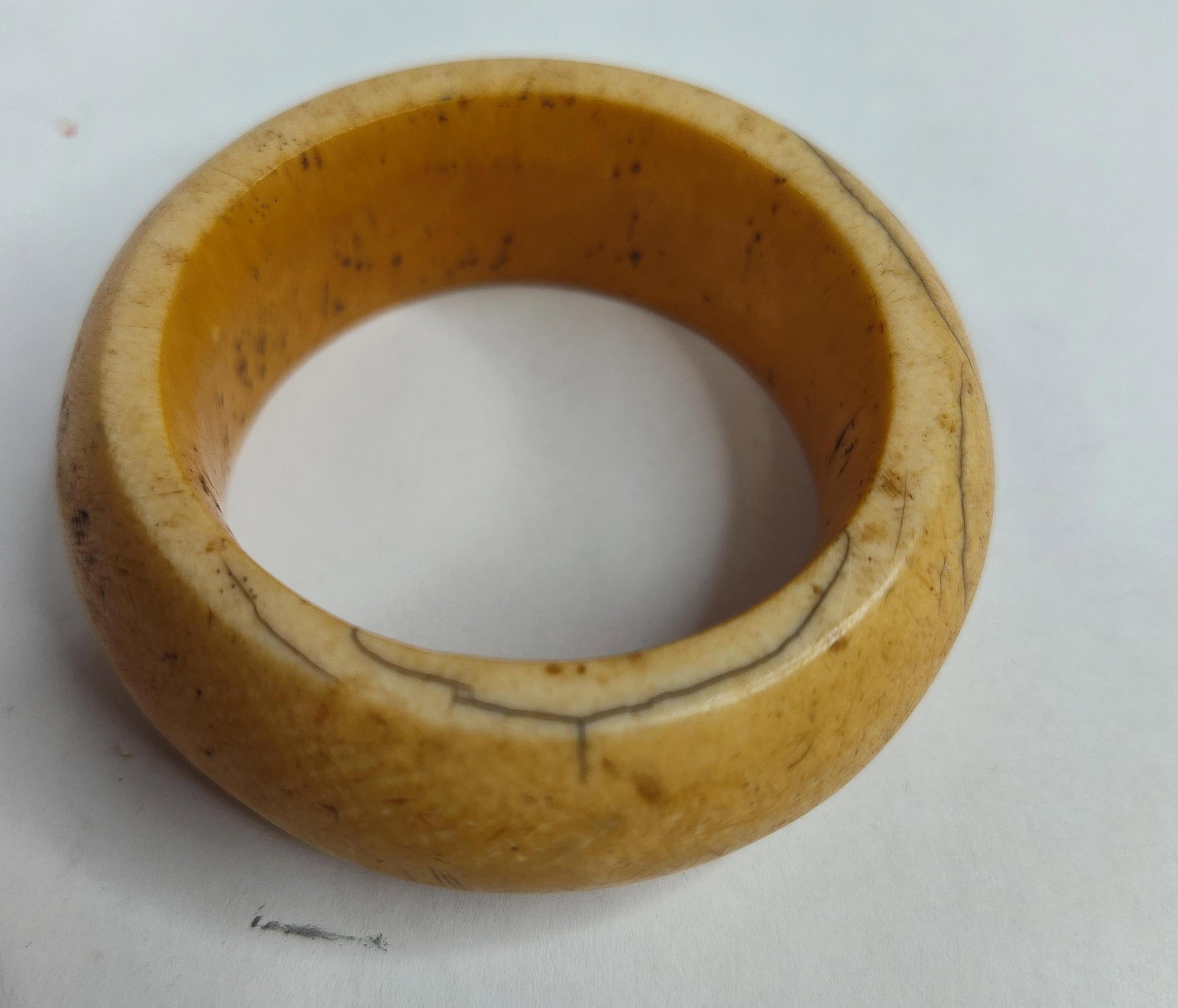 Antique Honey Patina Carved Bone Bangle: A wide, continuous-loop bangle bracelet crafted from a thick-walled organic material consistent with carved bone. The piece features a substantial, rounded convex profile and displays a deep, naturall