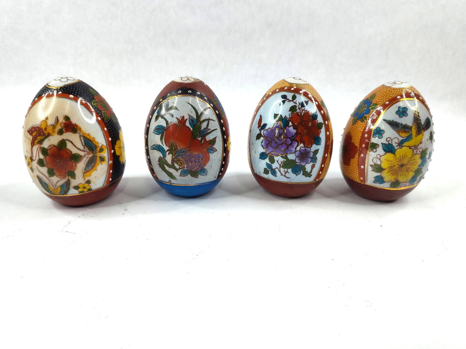 Set 4 Moriage Hand-Painted Porc. Eggs: A set of four Japanese-style decorative porcelain eggs featuring hand-painted overglaze enamels and gilded highlights. The decoration utilizes the moriage technique, consisting of raised white enamel