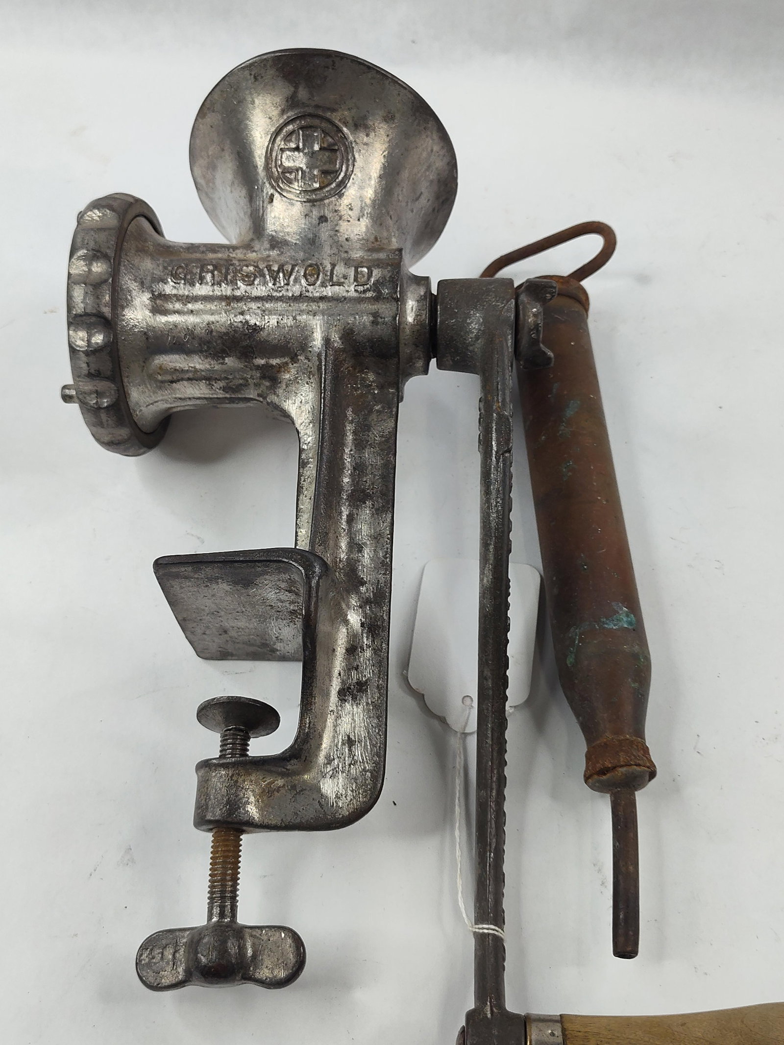 Vtg Griswold No. 4 Meat Grinder & Tool: This lot consists of two antique metal tools: a manual meat grinder and a separate hand-plunger tool. The meat grinder is identified as a No. 4 model manufactured by the Griswold Manufacturing