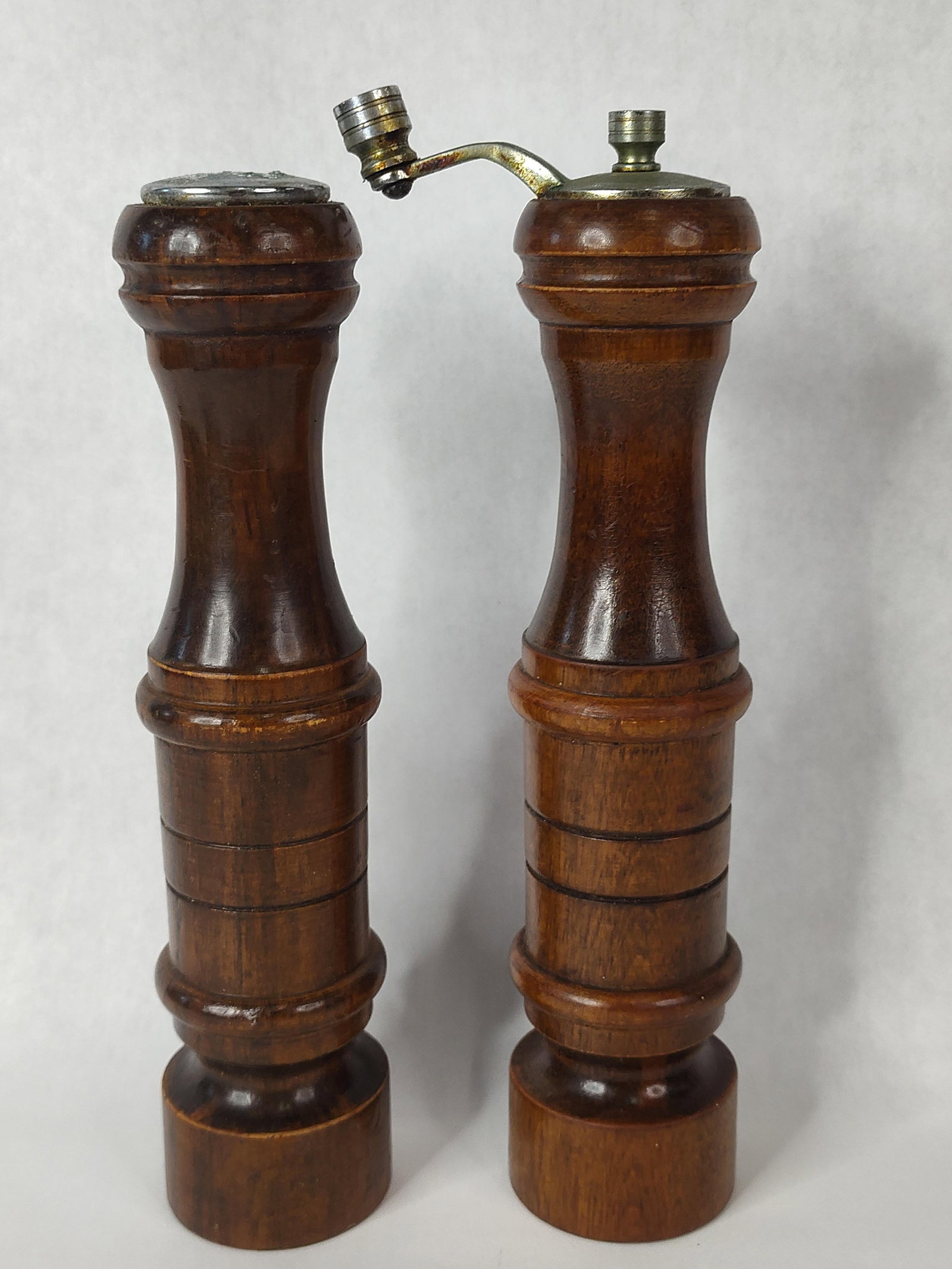 Pair Vtg Wood Salt Shaker & Pepper Mill: A matching pair of condiment dispensers, including one salt shaker and one pepper mill. Each piece is crafted from dark-stained turned wood featuring a waisted profile with decorative horizontal ring 