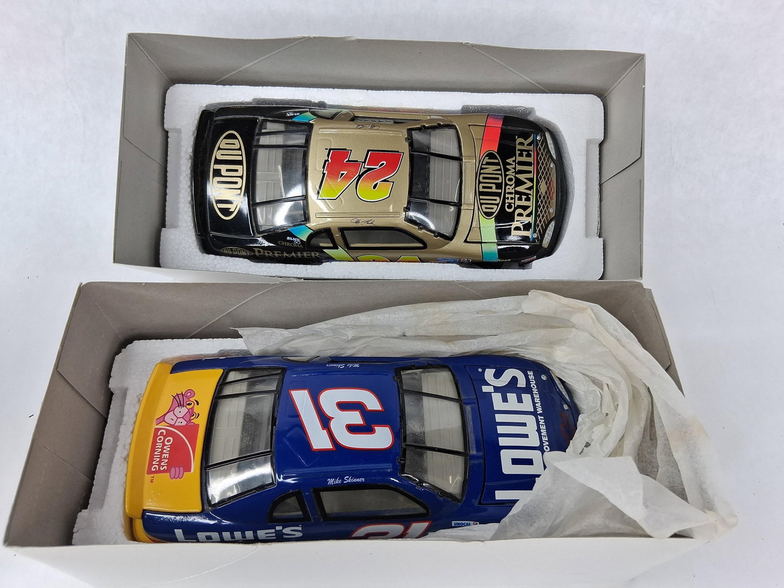 Pair 1997 NASCAR 1:24 Gordon & Skinner: This lot features two 1:24 scale diecast model cars representing the 1997 NASCAR Winston Cup season, manufactured by Action Performance Companies, Inc. The first model is a Jeff Gordon #24 Chevrolet M