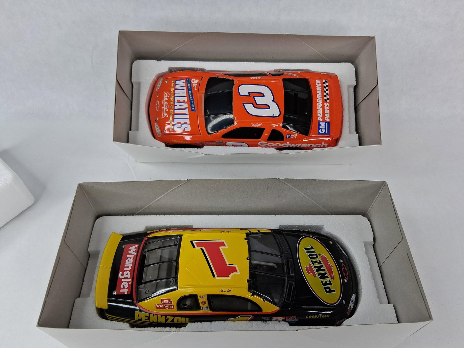 Action NASCAR 1:24 Banks Earnhardt/Park: This lot features two 1:24-scale die-cast NASCAR stock car banks manufactured by Action Racing Collectables, both presented in their original factory packaging. The first model is a 1997 Chevrolet Mon