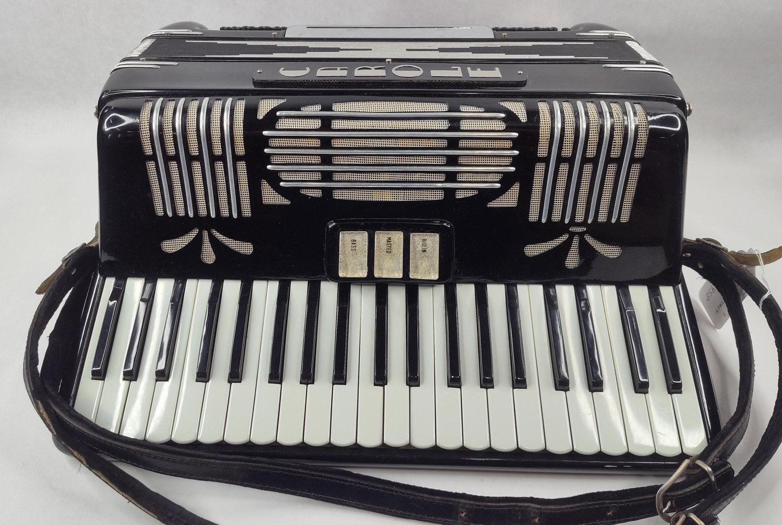 Carole 120-Bass Italian Piano Accordion: A Carole piano accordion produced in Italy. The instrument is constructed with a black celluloid-finished casing and features a 41-key piano keyboard and a 120-button bass system. The decorative metal